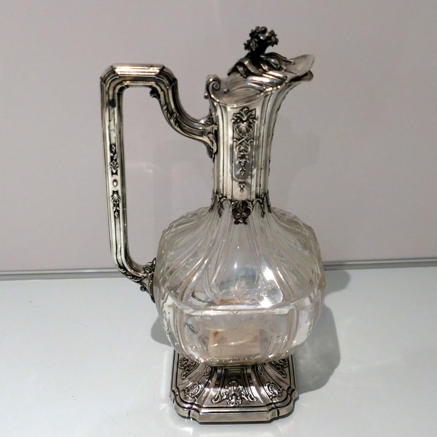 An extremely stylish antique silver and crystal claret jug designed with a rare and extremely sumptuous shaped square etched bowl. The mount has beautifully ornate mouldings and the stylish flip hinged lid is mounted with an elegant