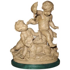 Statue française en terre cuite de la fin du XIXe siècle représentant une putti taquinant un chien oiseau