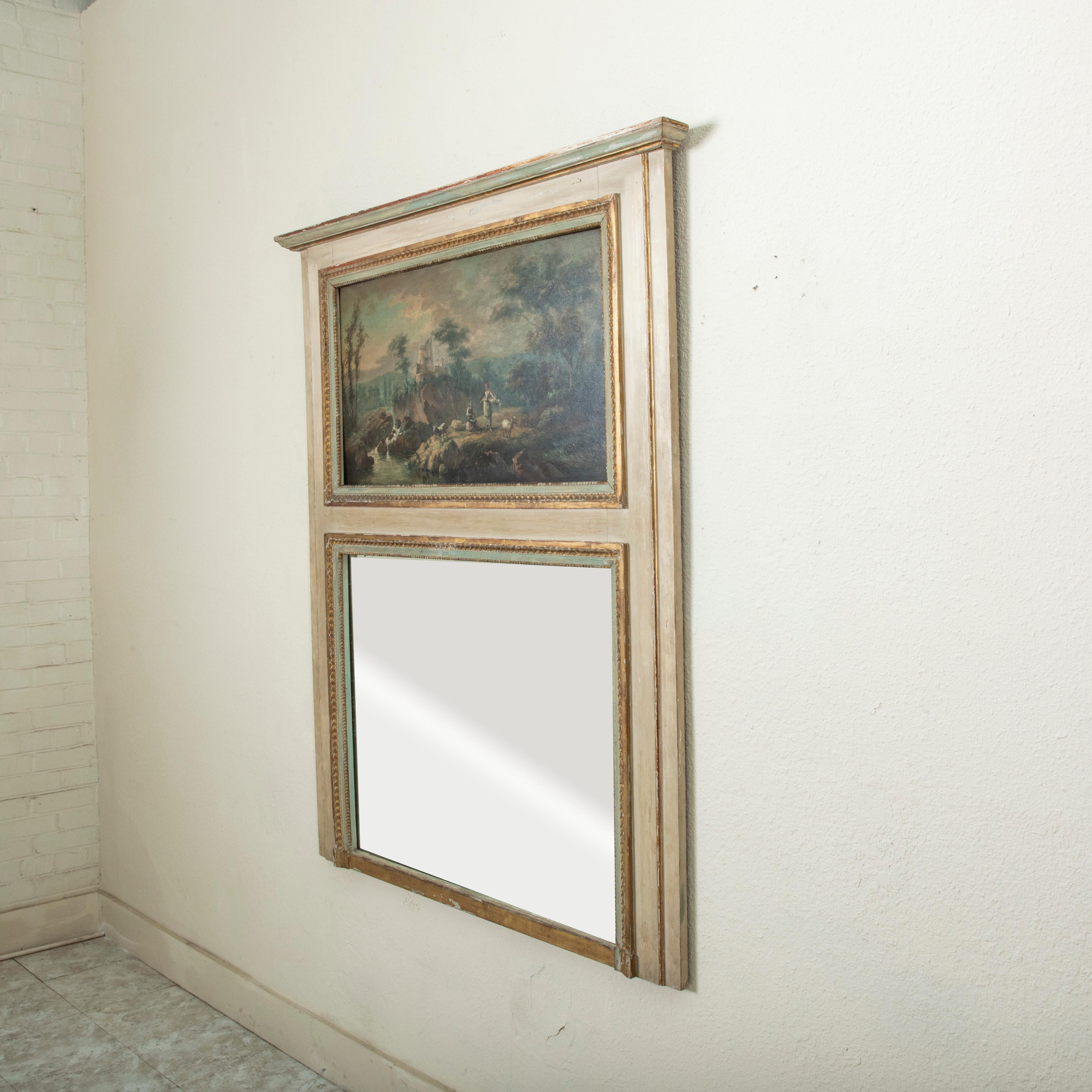 This late nineteenth century French Louis XVI style trumeau mirror features its original mercury glass and oil painting above. The mirror is detailed with gilded borders of a rais-de-coeur pattern and beading that surround the mirror and painting.