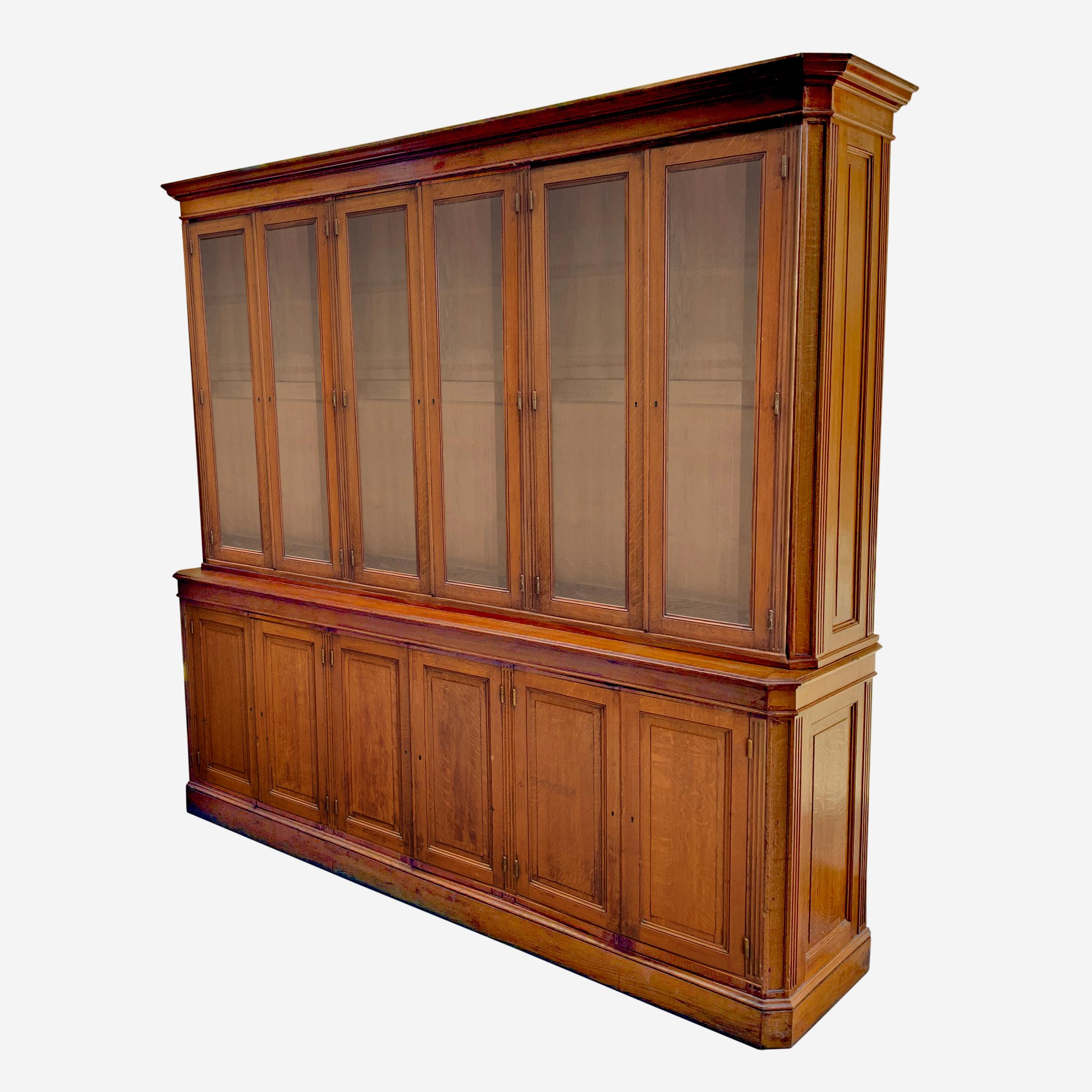 An incredible 19th century French oak breakfront cabinet with twelve doors, six with glass and six without, with adjustable shelves, brass bullet hinges, and a wonderful presence! Perfect for your butler's pantry, kitchen, or any number of other