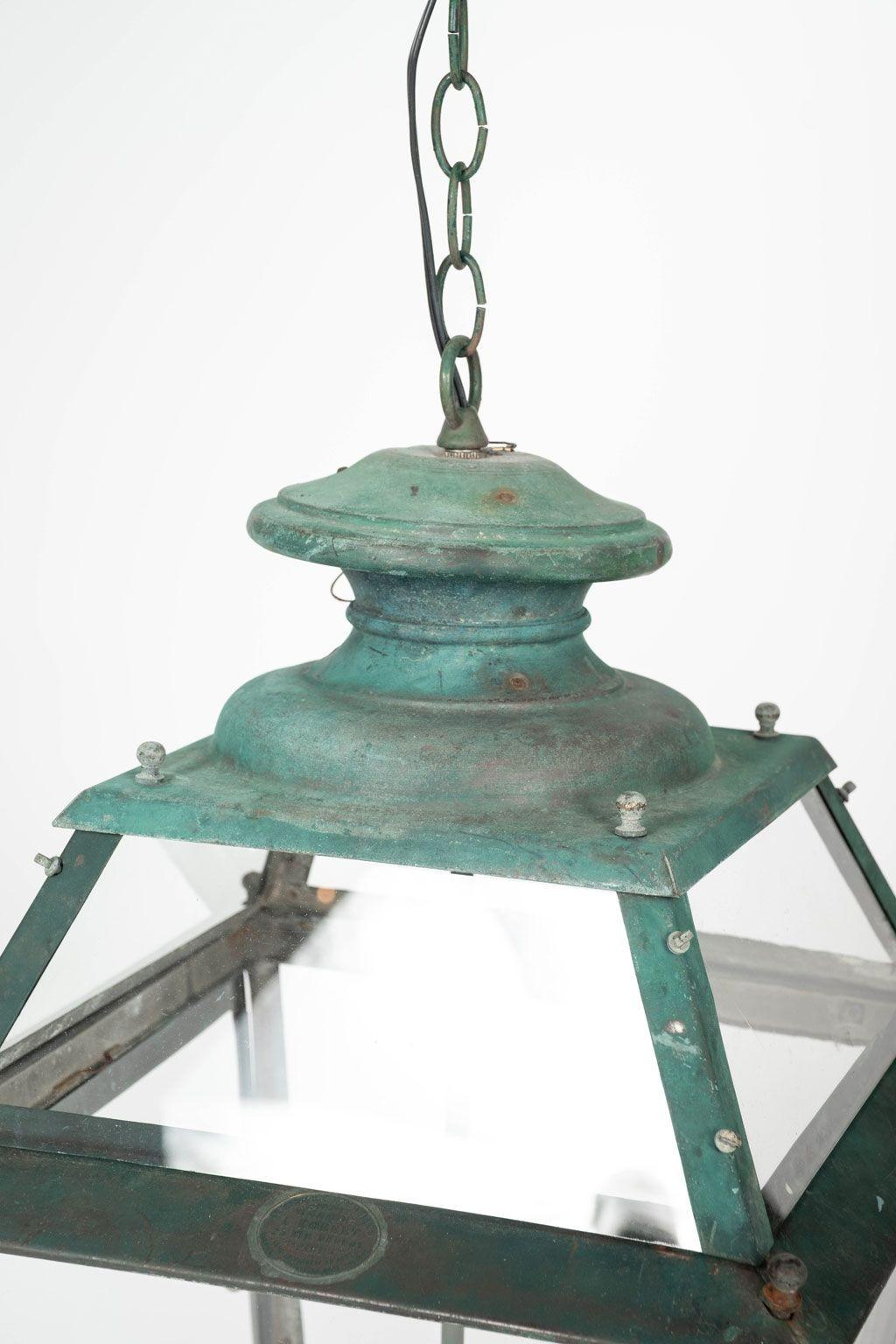 Late 19th century verdigris green copper glass paneled lantern circa 1880-1899. Originally created to be a gas street lamp. Maker's mark. Now electrified with a three-candelabra drop cluster. Four additional feet of chain and canopy included (listed