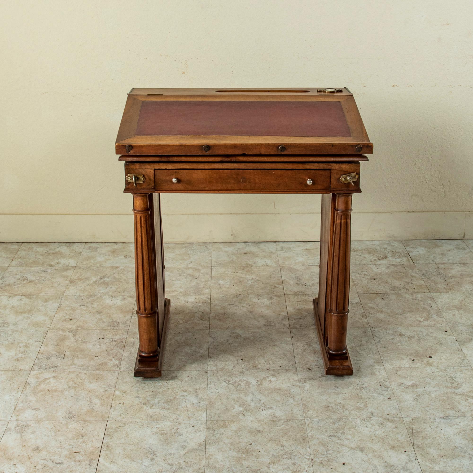 The model for this late nineteenth century French walnut architect's desk was originally exhibited at the World's Fair in Paris in 1889 where it won a silver medal. This desk features a brass plaque on the side marked, Table Feret, 16 Rue Etienne