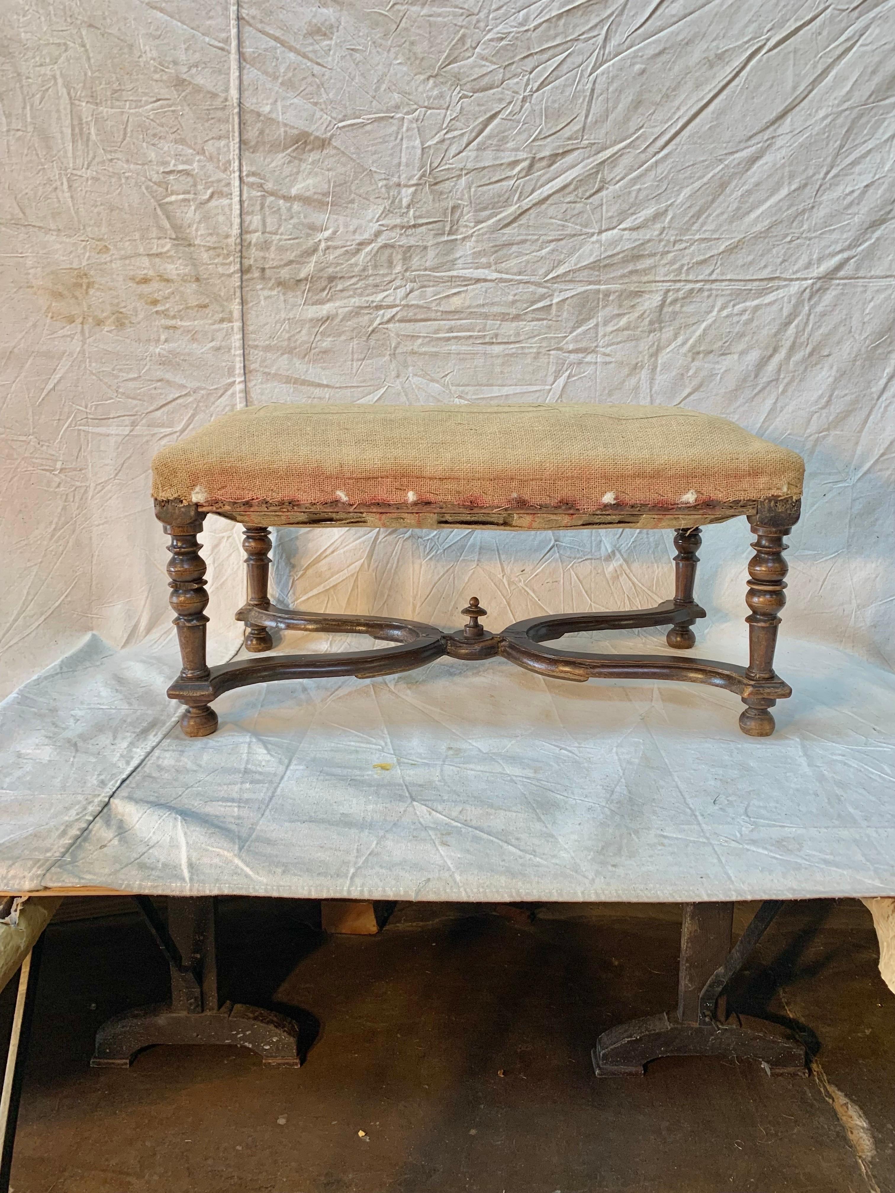 Found in the South of France, this Late 19th Century French Walnut Ottoman is presented as found with deconstructed upholstery. The hand turned and carved legs and stretchers are unique and beautiful. The ottoman features lovely detail and is ready