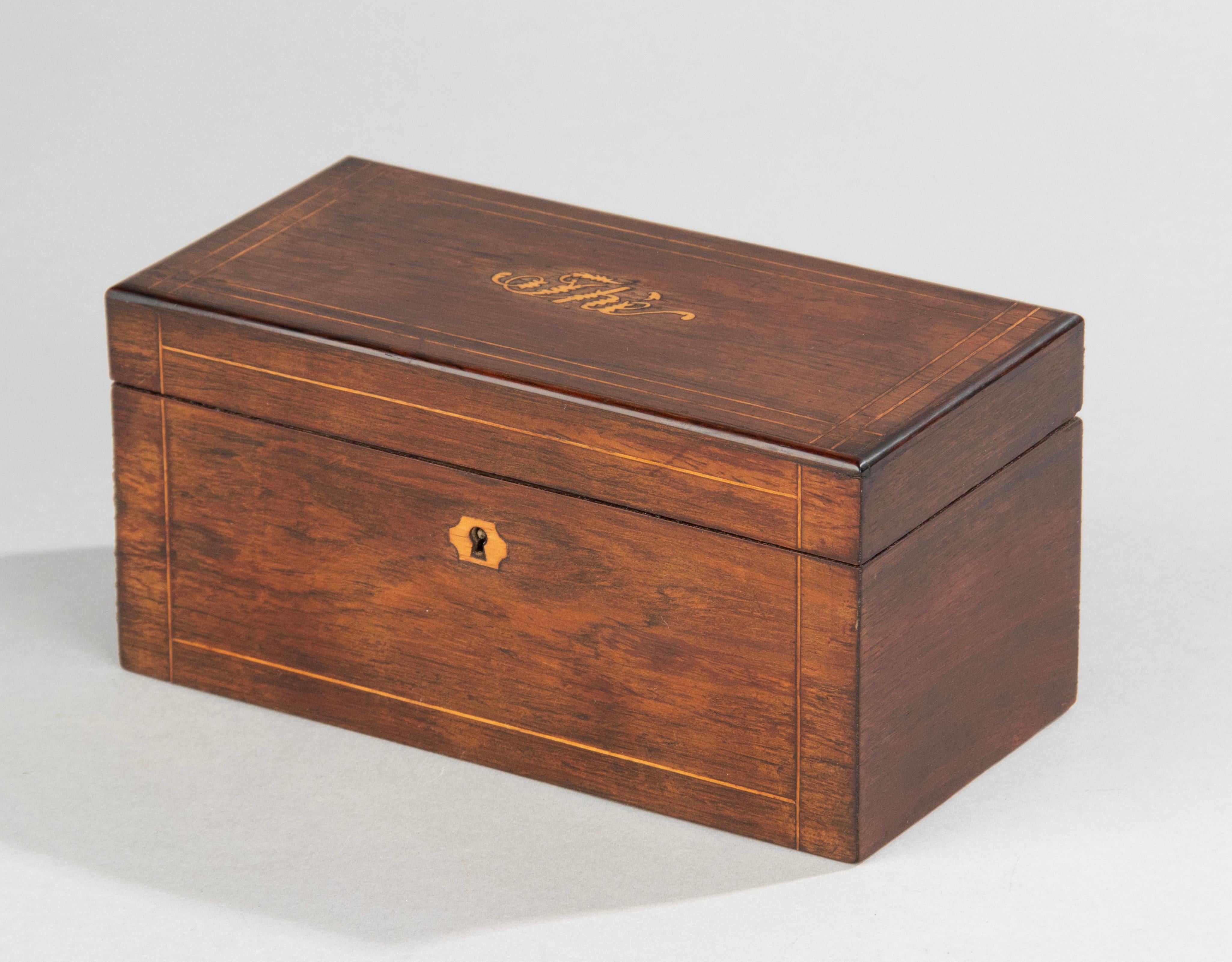 An antique French tea caddy in Napoleon III style. The box is made of veneer beechwood, with beautiful grain. The lid is in slayed with lighter maple wood. At the center wood inlanders of Thé (French for Tea). Inside two compartments made of