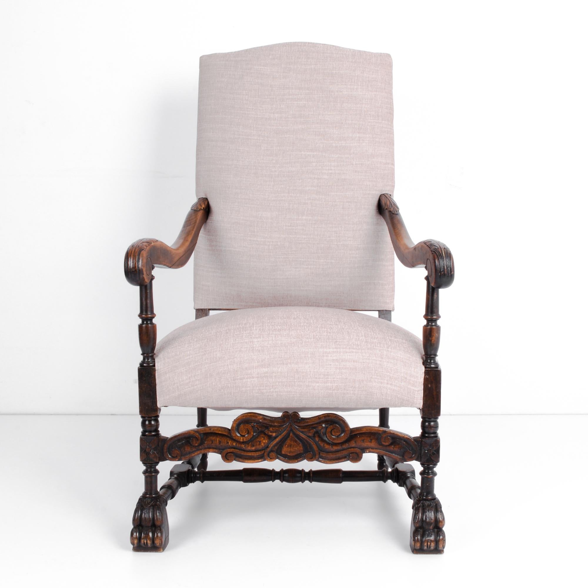 This wooden armchair was made in France, circa 1880. It has an upholstered and well-padded seat and back. The claw feet and intricate carvings on the front stretcher and armrests highlight the detailed care that has gone into this chair. The deep