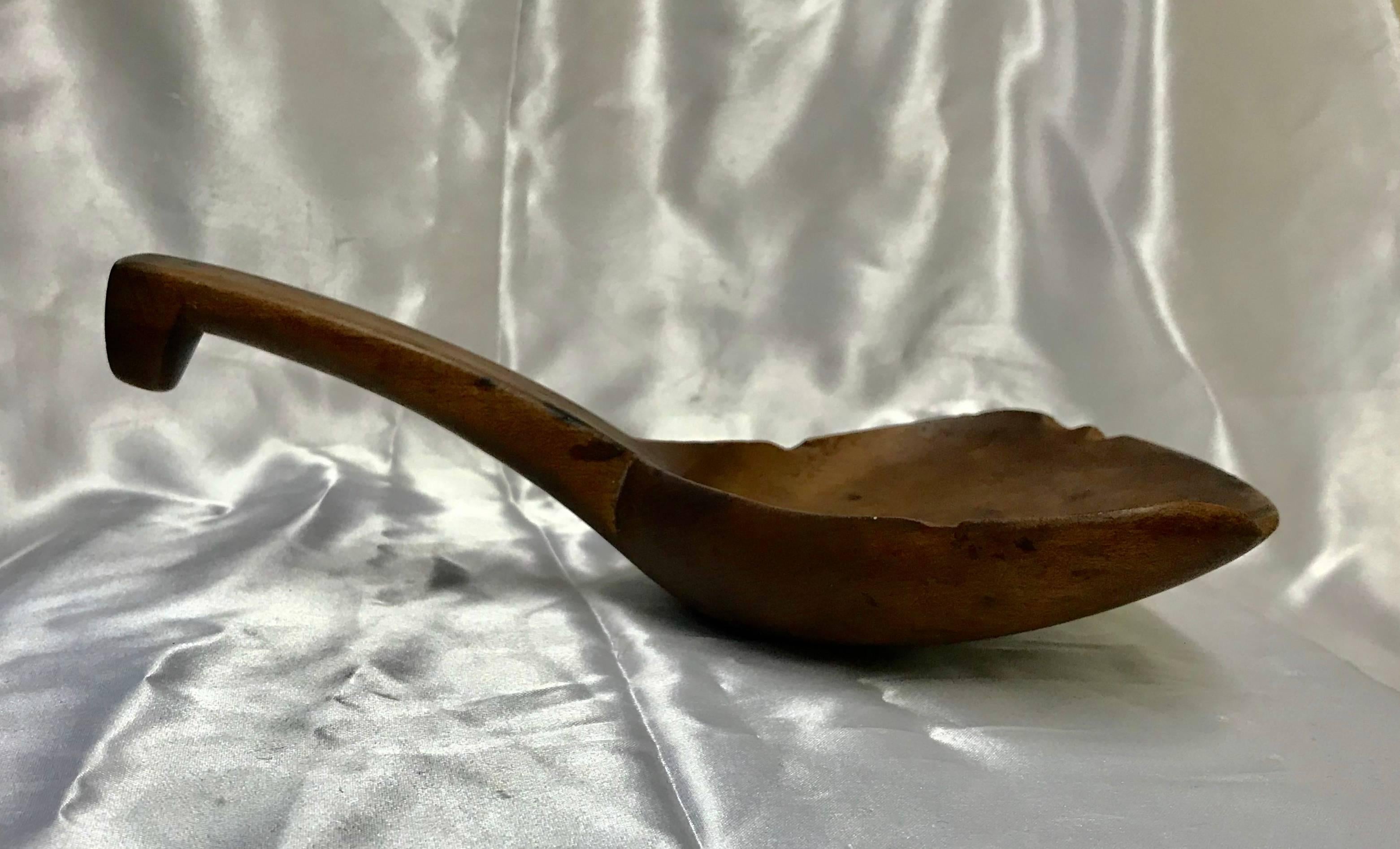 You can still see the grain of the wood in this late 19th century wooden spoon or paddle from France. It has stirred many pots as you can tell from the wear on the edge. There are even some burn marks where they possibly got the fire a little too