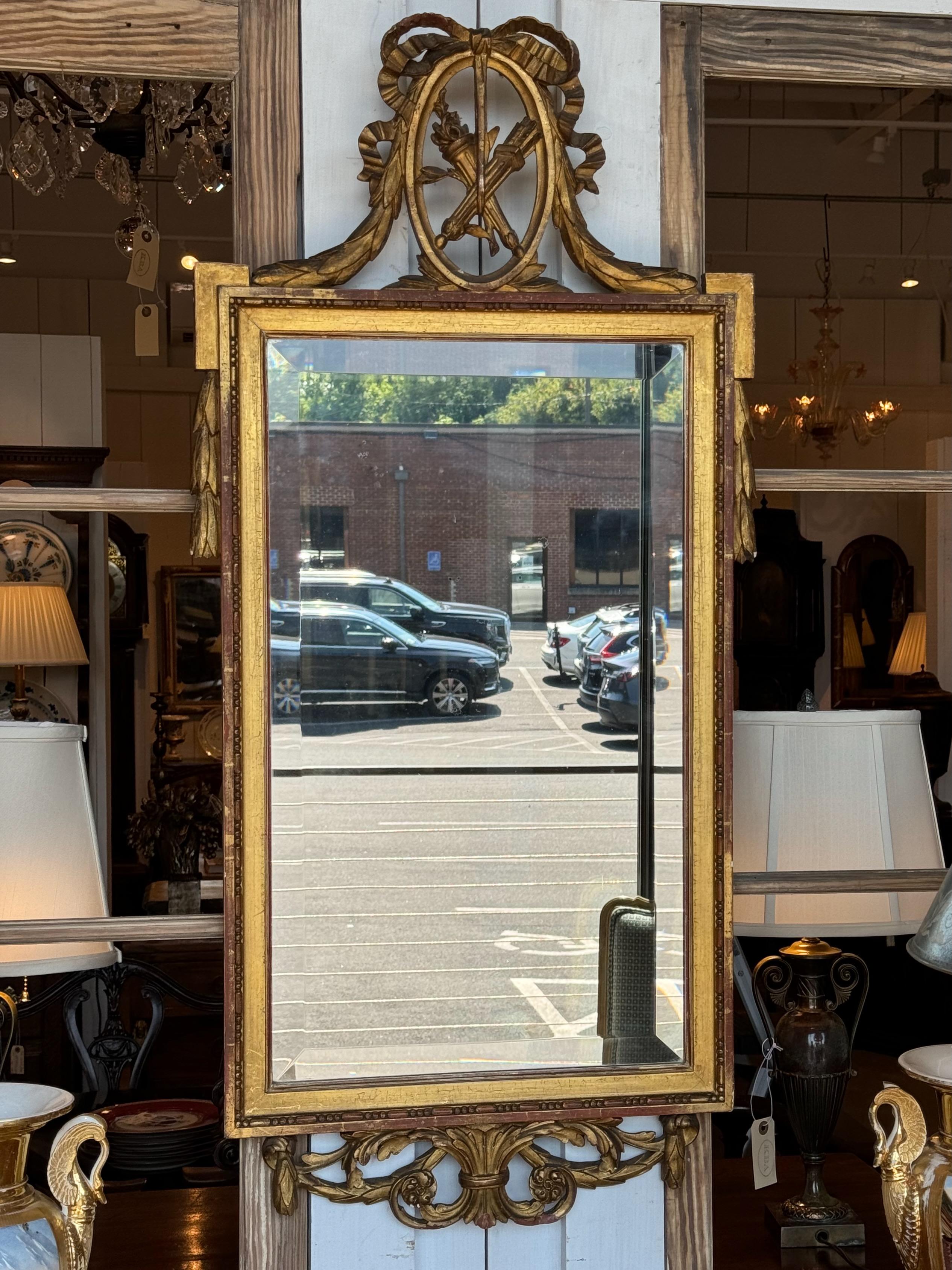 A pretty gilded mirror . Place this in a powder room.