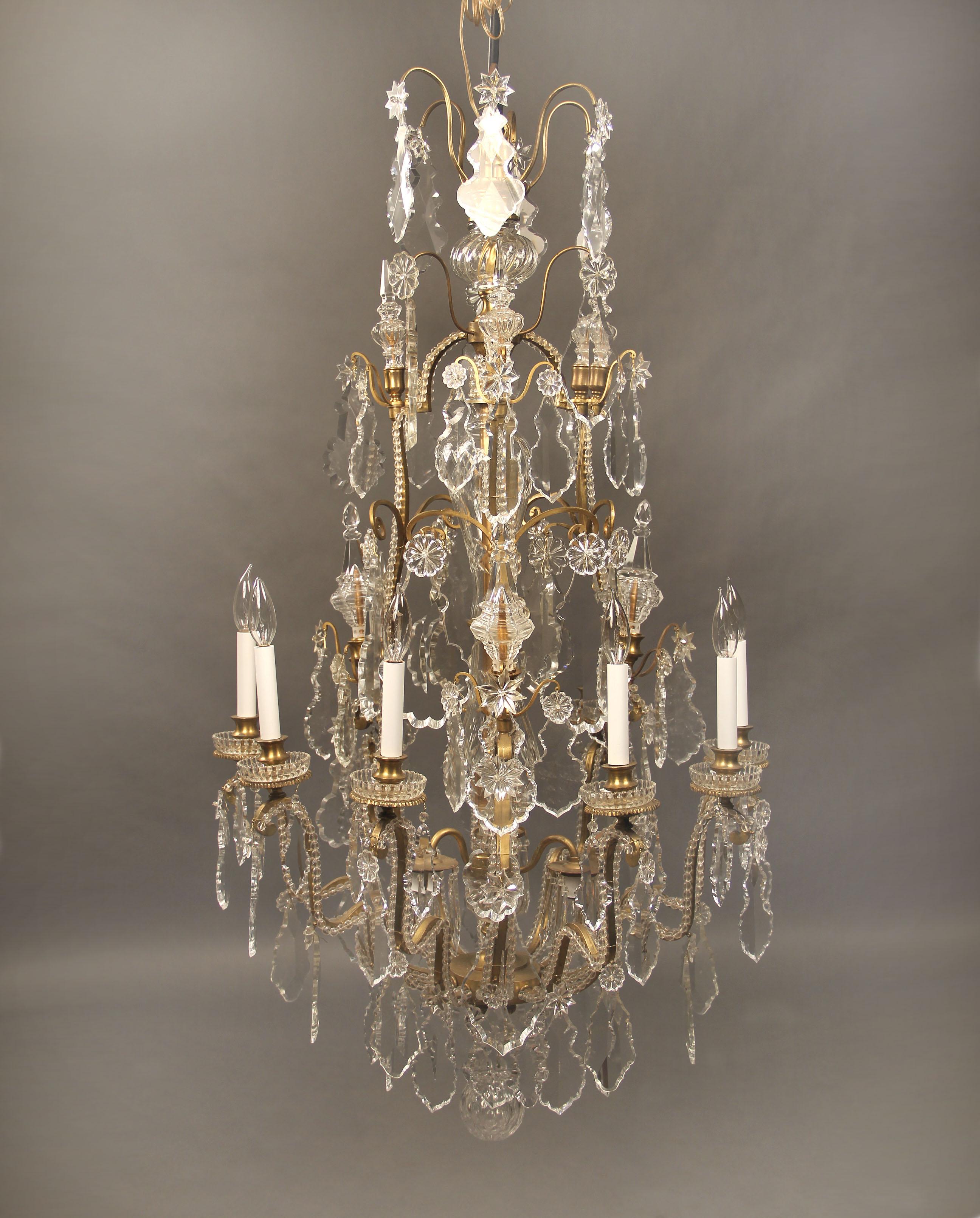 A wonderful late 19th century gilt bronze and baccarat crystal twelve-light chandelier

multifaceted and shaped crystal, beaded arms, cut crystal central column, six tiered spears, twelve perimeter lights, bobeche cups.