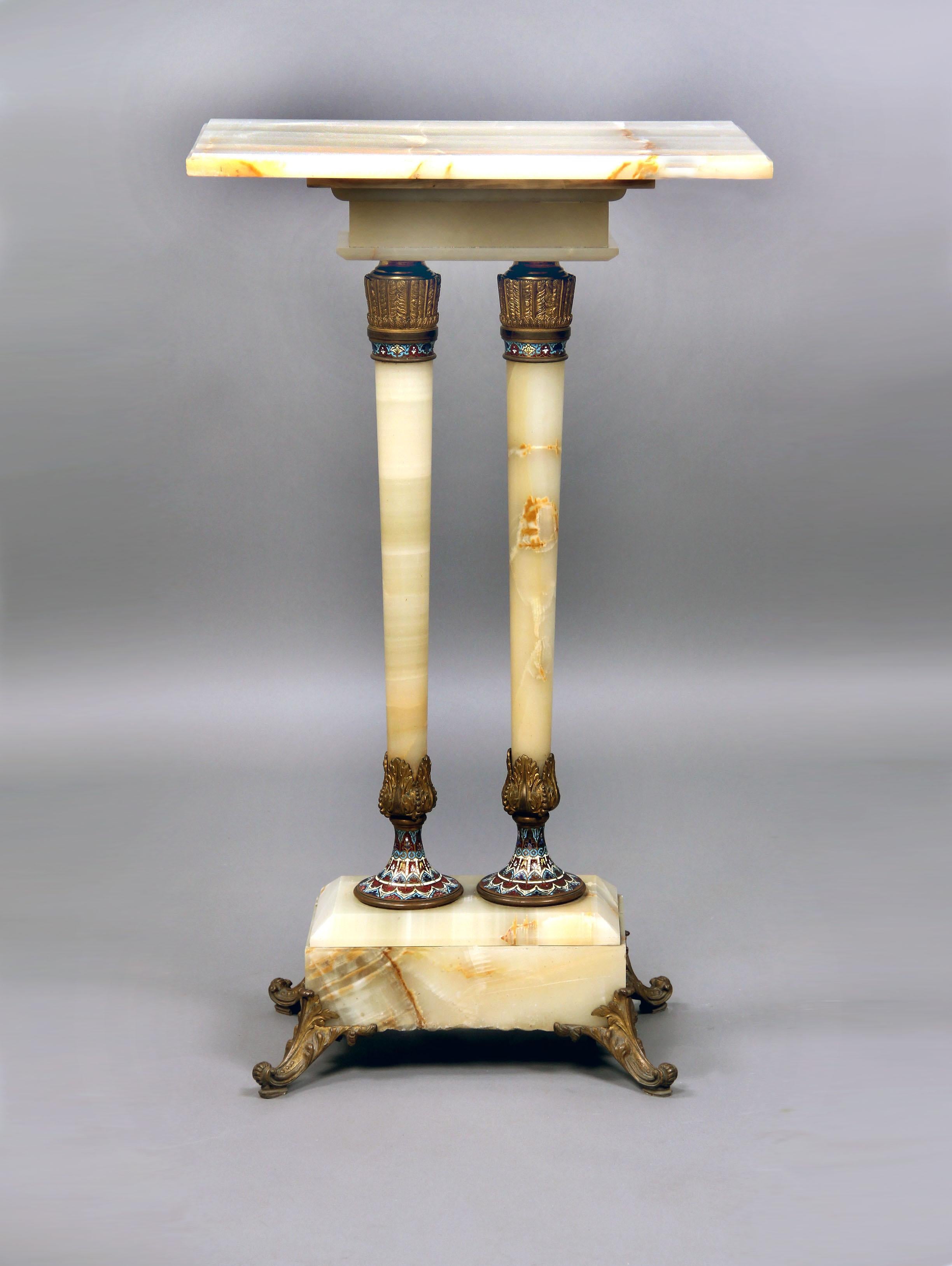 Late 19th Century Gilt Bronze and Champleve Enamel Mounted Onyx Pedestal

Rectangle onyx top above a pair of gilt bronze and French enamel pillars leading down to similarly decorated bronze and enamel designs, standing on a onyx base with four