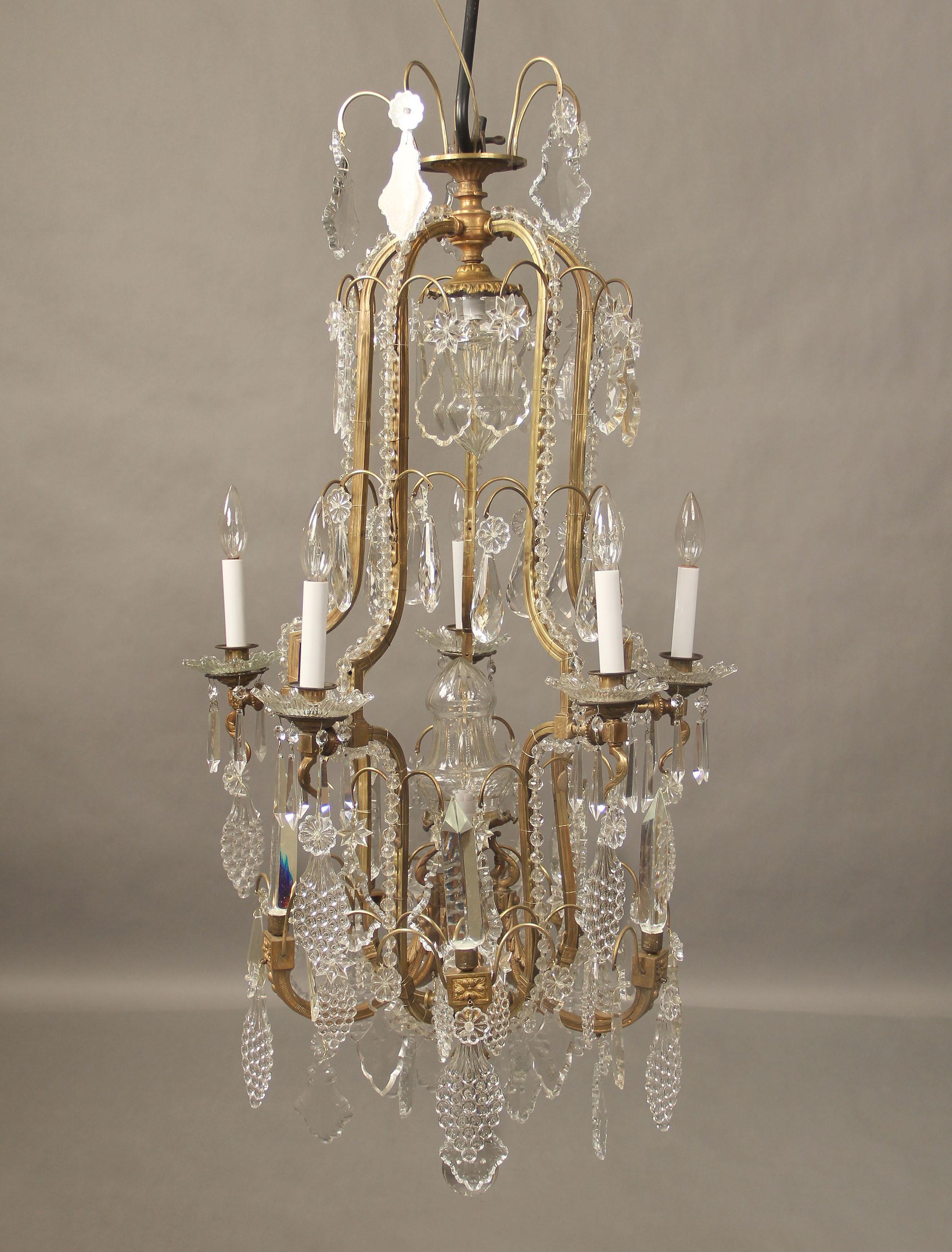 A lovely late 19th century gilt bronze and crystal seven light chandelier.

Multifaceted and shaped crystal, some designed as grapes, beaded arms, five exterior crystal prisms, five perimeter and two central interior lights, bobeche cups.

 