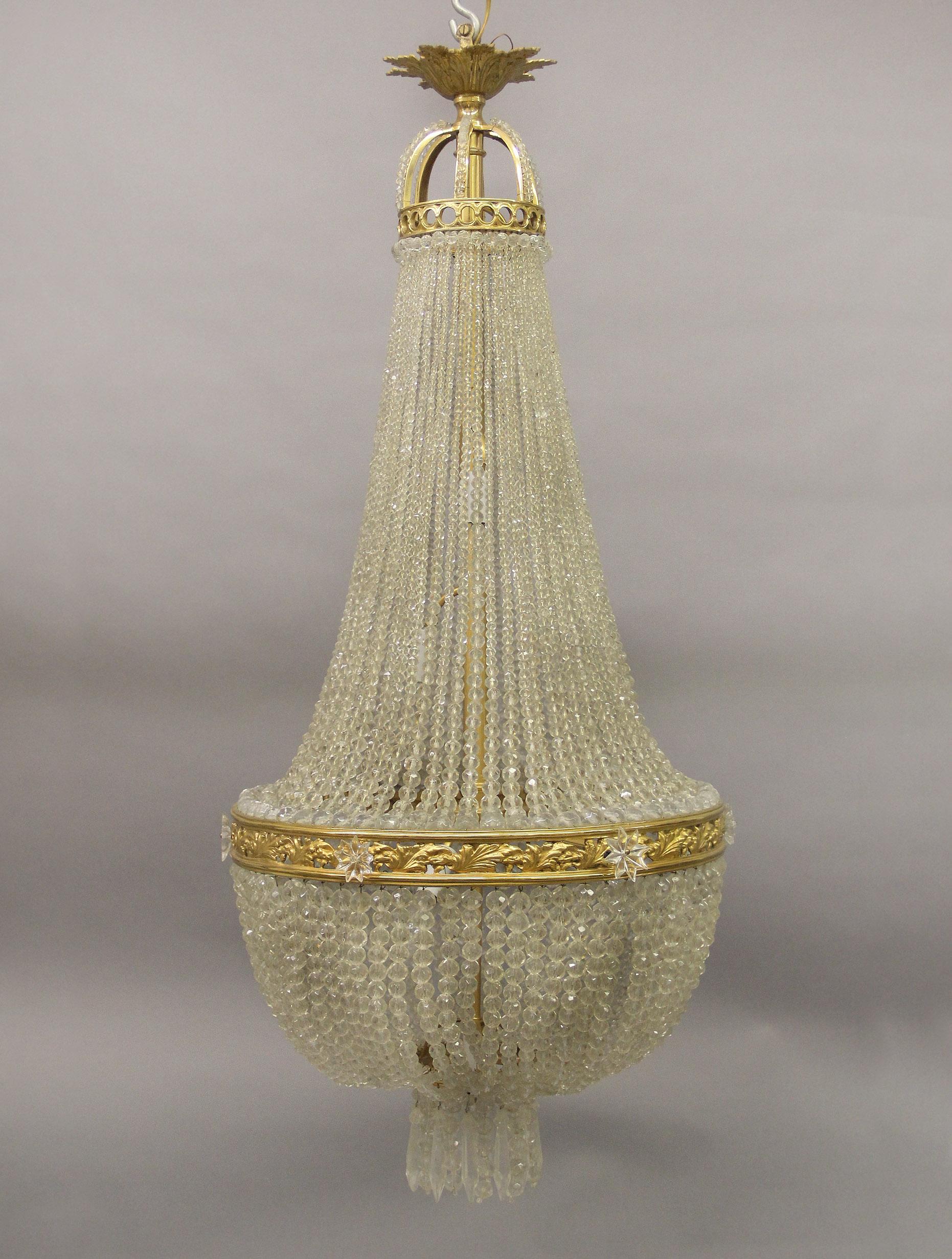 Lampadario a cesto a sette luci in bronzo dorato e cristallo della fine del XIX secolo

La corona di perline in bronzo ha un design reticolato, perline fluenti che scendono verso un cesto con cristalli a goccia, sette luci interne a