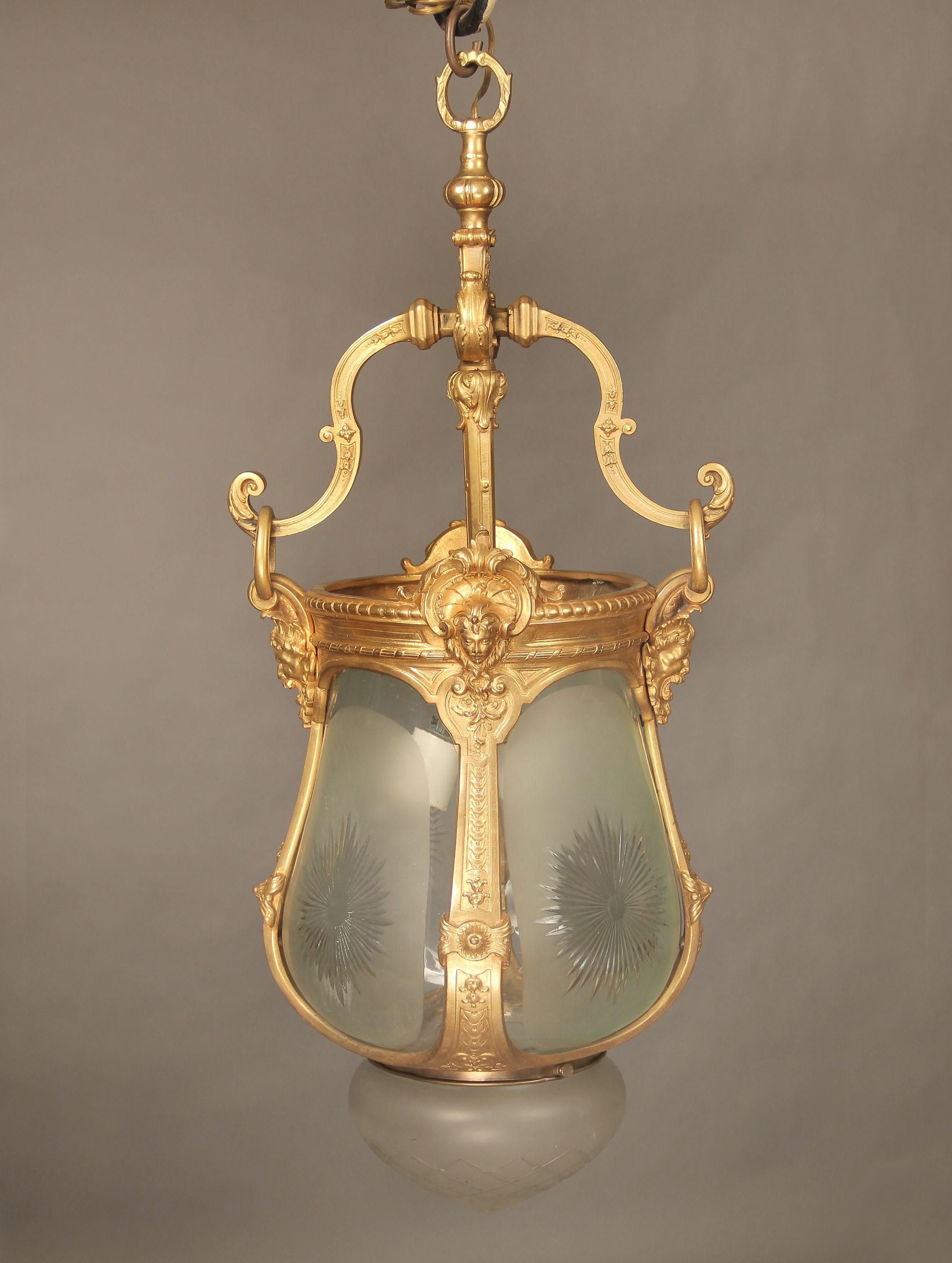 A late 19th century gilt bronze and cut-glass hall lantern 

With male and female masks along the top, the base with a crystal etched dome. Two interior lights.

 