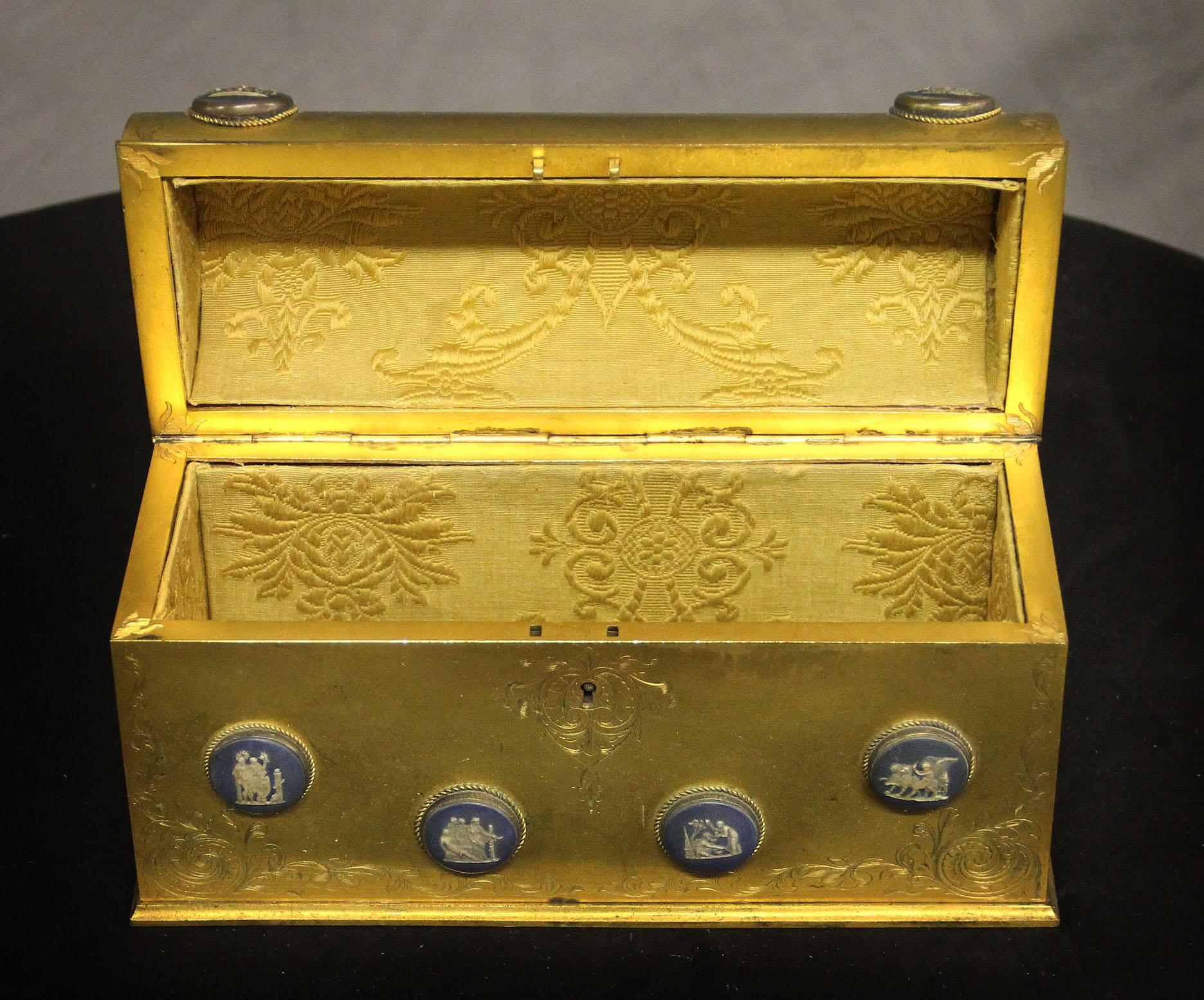Late 19th century gilt bronze and Wedgwood style porcelain etched jewelry box

The etched gilded box mounted with twelve blue porcelain plaques depicting different classical scenes, the top opens to a fabric interior.