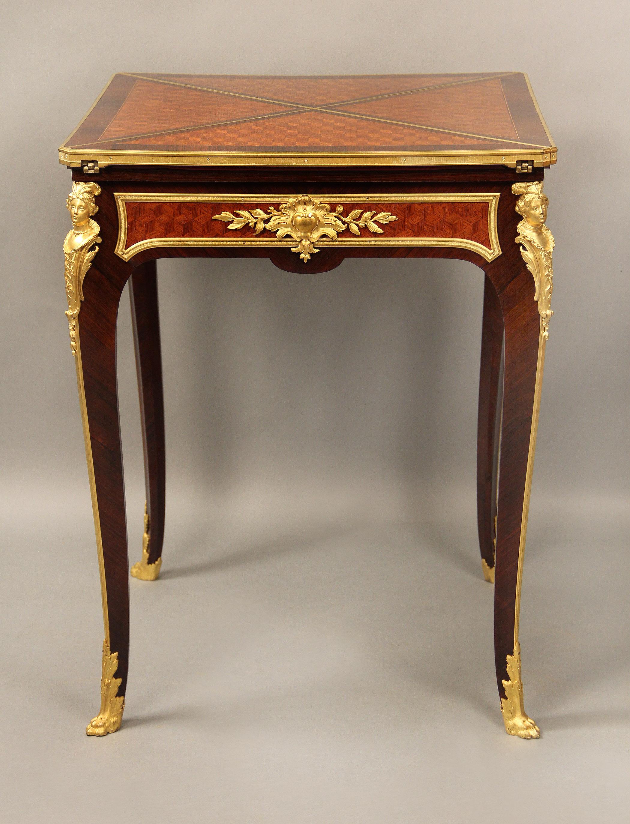 A wonderful late 19th century gilt bronze mounted parquetry envelope game table by François Linke

François Linke – Index no. 523

The revolving top with four triangular leafs, opening to green baize-lined playing surface above a frieze fitted