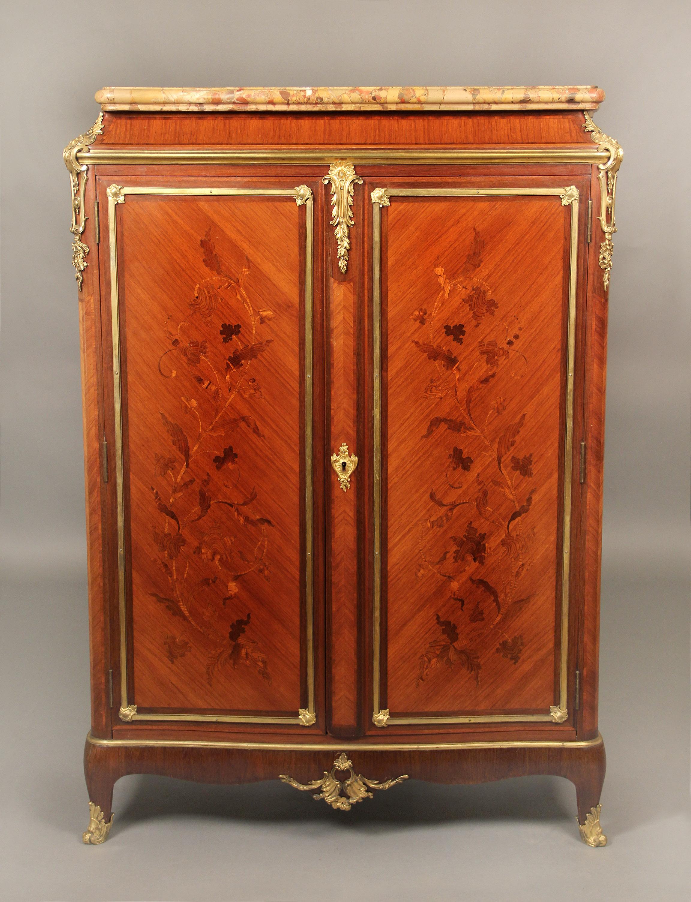 A fine late 19th century gilt bronze mounted Transitional style Marquetry cabinet

By Durand

The marble top above two long inlaid floral doors which open to three adjustable wooden shelves, each corner with bronze mounts of scrolled acanthus