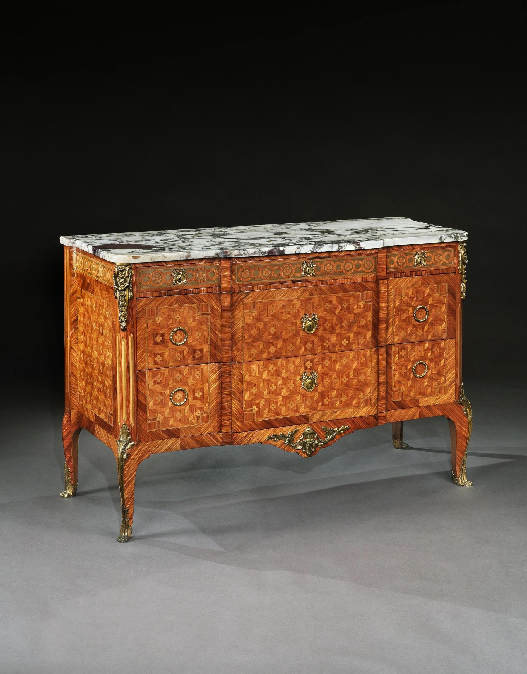 An outstanding gilt bronze-mounted tulipwood, kingwood and sycamore parquetry breakfronted breche violet marble topped commode, in French Transitional style dating to the late 19th-early 20th century.

French, circa 1880-1900.

Of superb