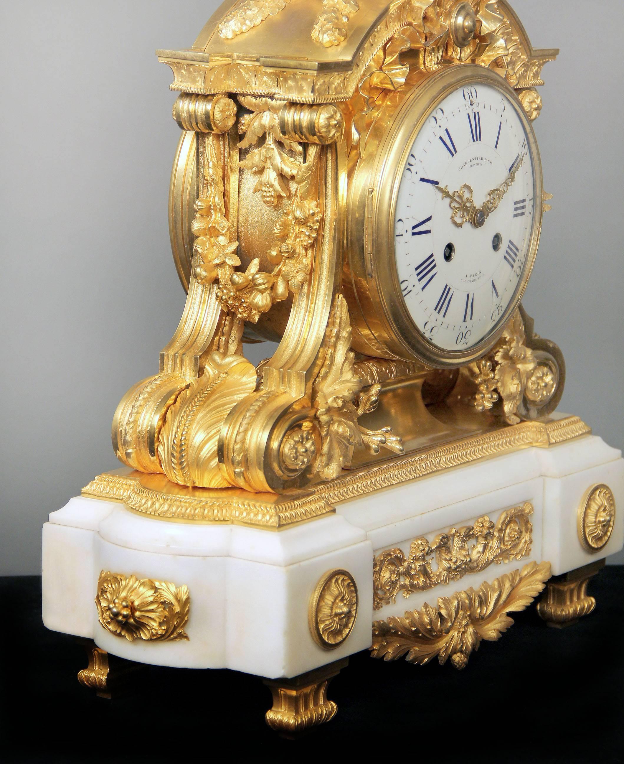 Une horloge de manteau de qualité fantastique de la fin du 19ème siècle en bronze doré et marbre blanc.

Par Charpentier & Compagnie.

Une urne avec des feuilles de laurier au-dessus d'un nœud noué, les côtés avec des guirlandes de fleurs et de