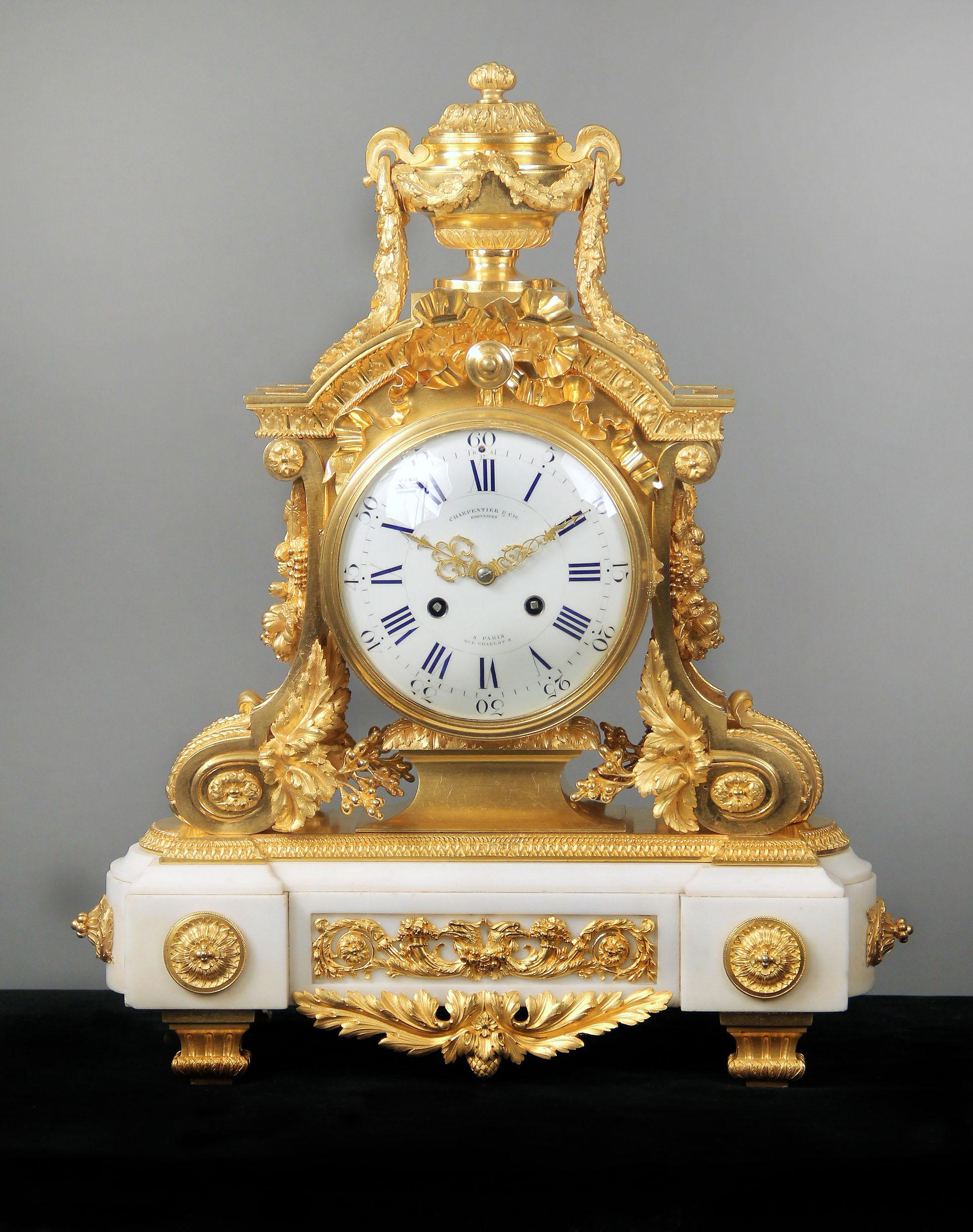 A fantastic quality late 19th century gilt bronze mounted white marble mantle clock.

By Charpentier & Compagnie.

An urn with laurel leaves above a tied bow, the sides with swags of flowers and fruit, the marble base mounted with a double eagle