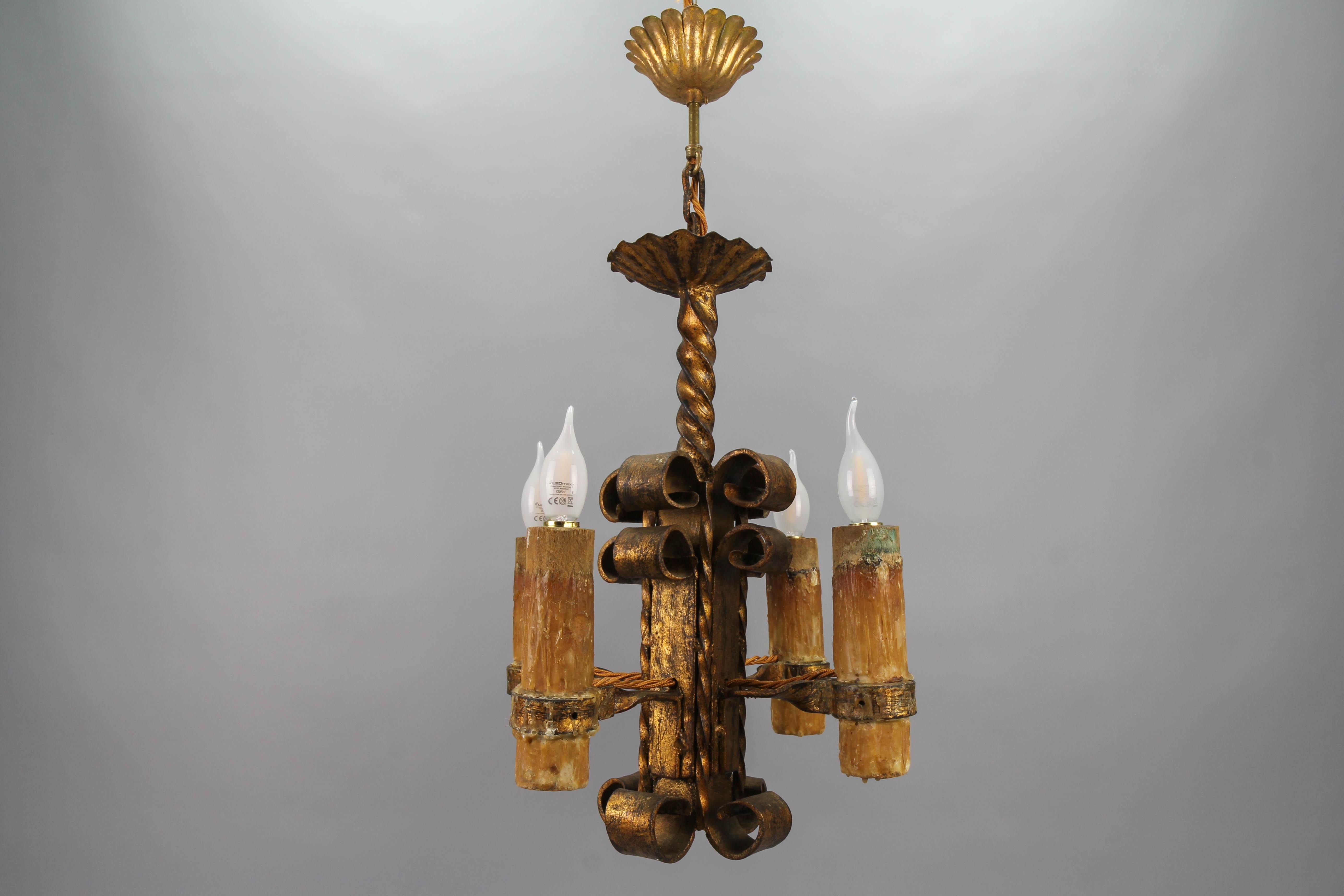 Late 19th century gilt wrought iron medieval style four-light chandelier
An impressive and heavy medieval-style castle design gilt wrought iron four-light chandelier from the late 19th century. The large decorative wooden candle sleeves are covered