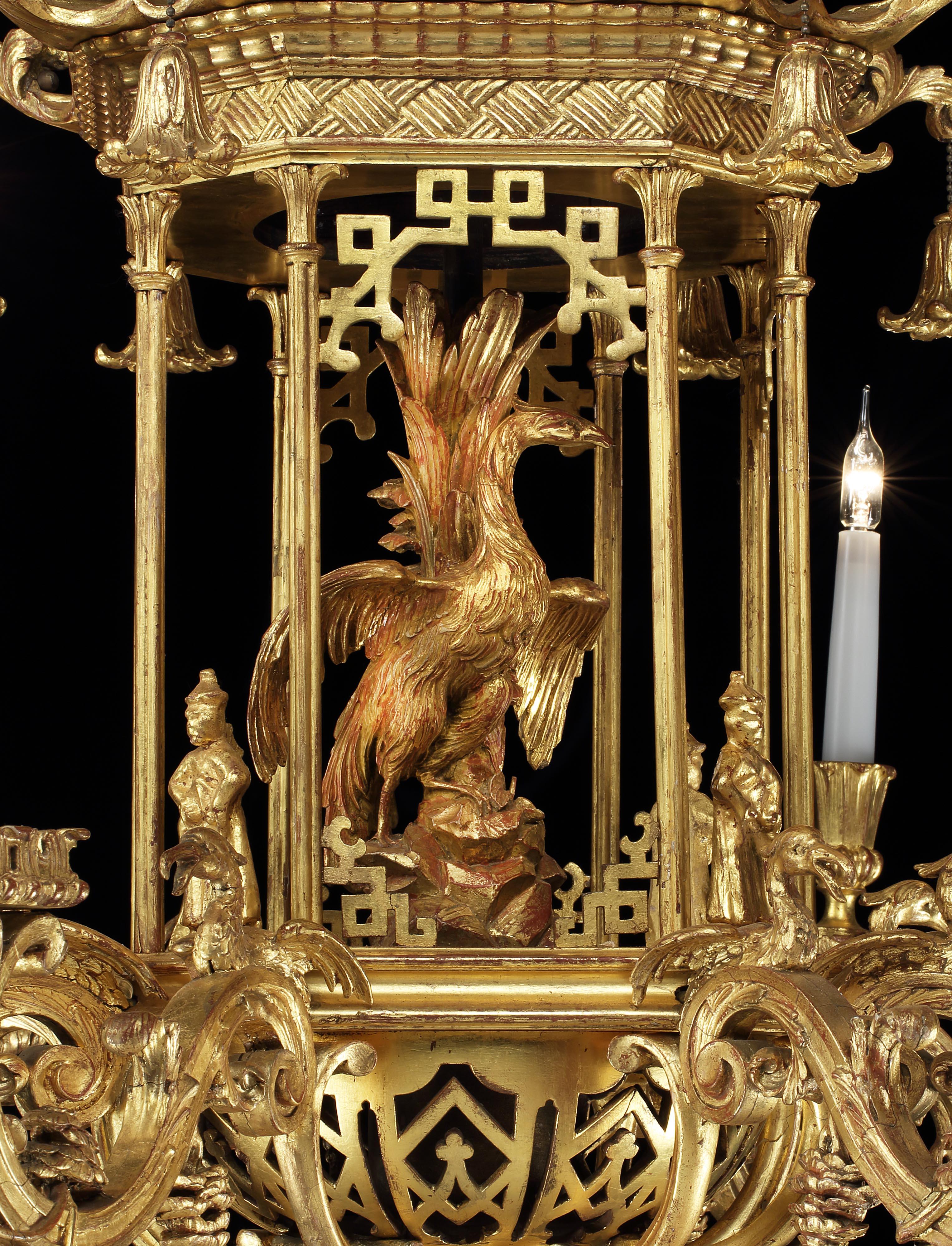 An exquisite chandelier in the Chinese Chippendale manner.

The whole in carved and giltwood, the eight arms, adorned with resting Ho-Ho birds emanate from a central octagonal cage, with Chinese fretwork, and a large carved Ho-Ho bird inside;