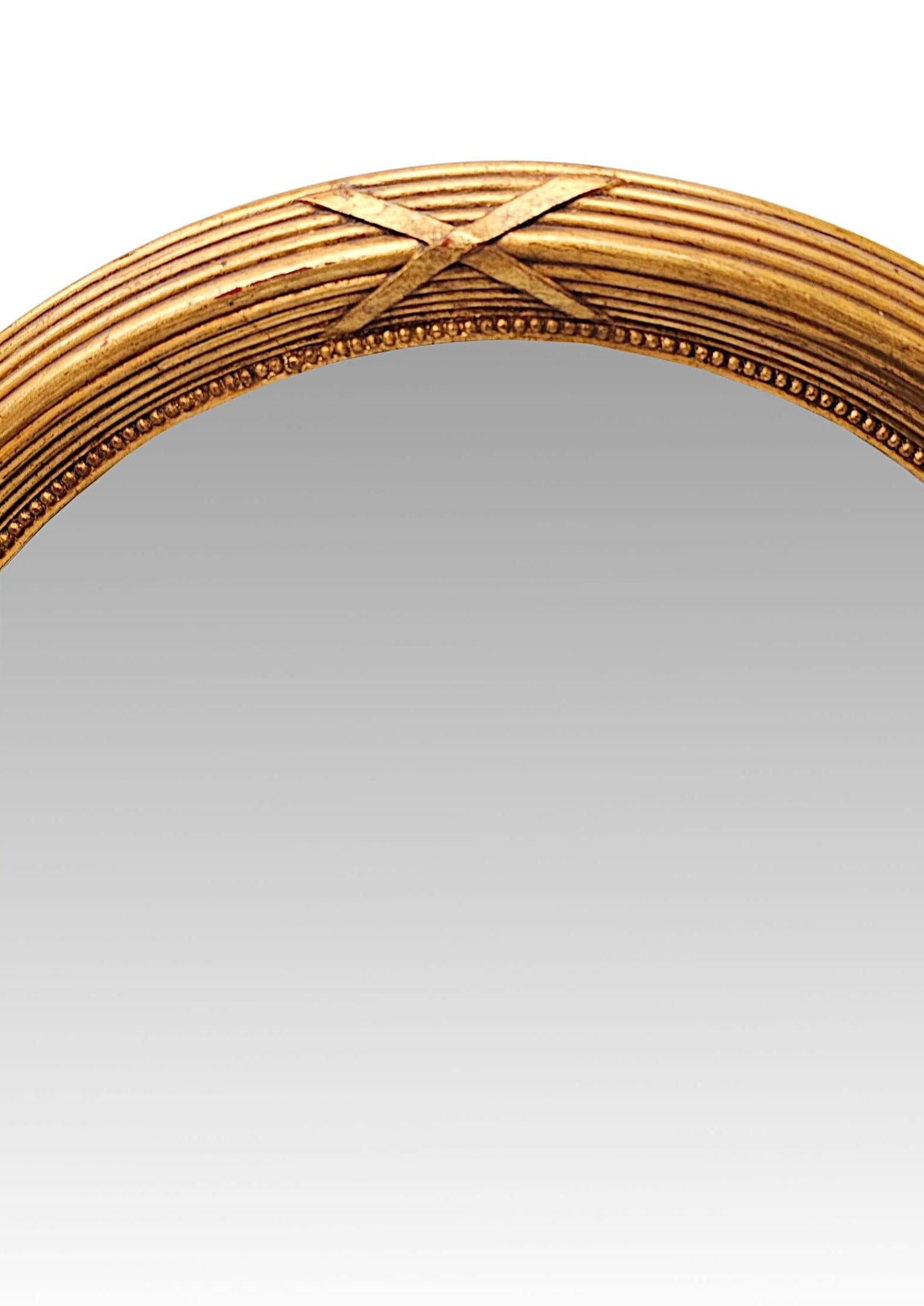 Un superbe miroir en bois doré de la fin du XIXe siècle, au design simple et élégant, d'une qualité exceptionnelle, qui peut être suspendu à la fois en format paysage et portrait.  La plaque de verre miroir de forme ovale est enchâssée dans un cadre