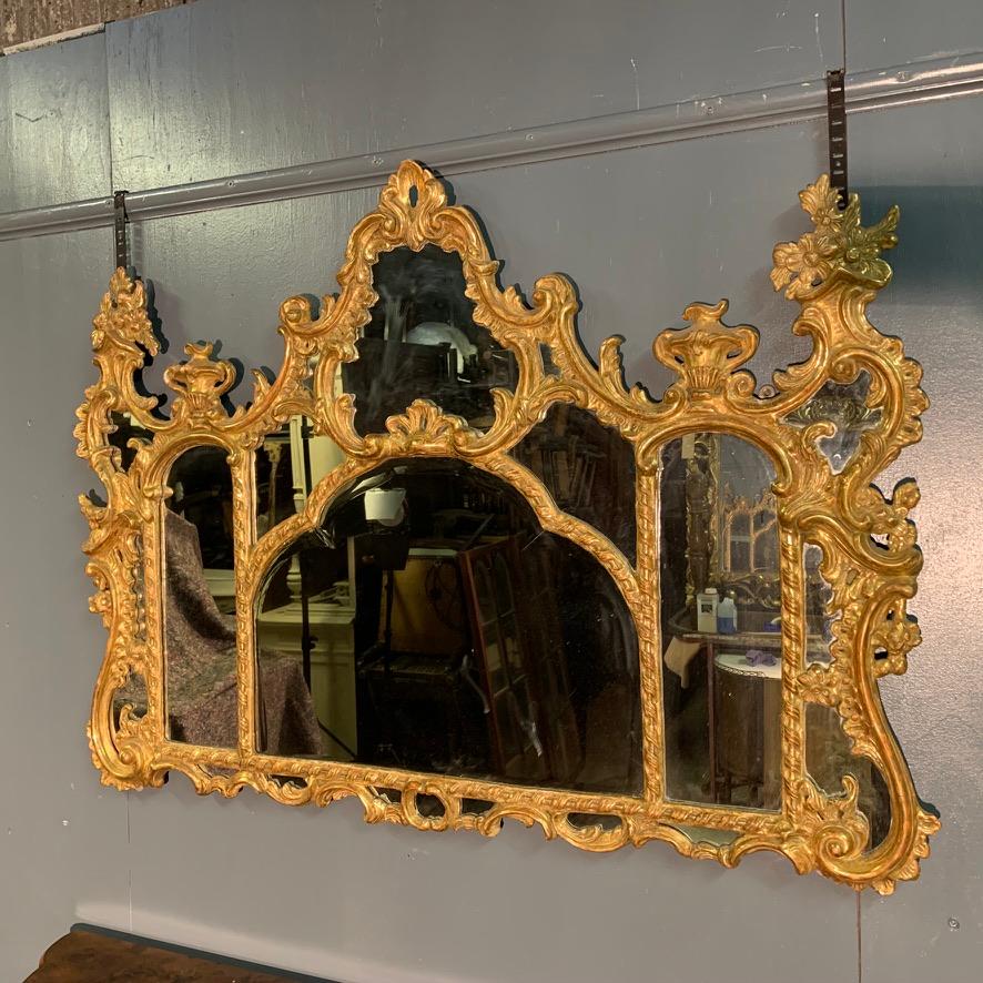 A very decorative and useful size giltwood mirror with original bevelled edge mirror to the centre and original plain mirror glass to the rest of the frame.
Beautiful carving throughout the frame and would work very well as an overmantle mirror,