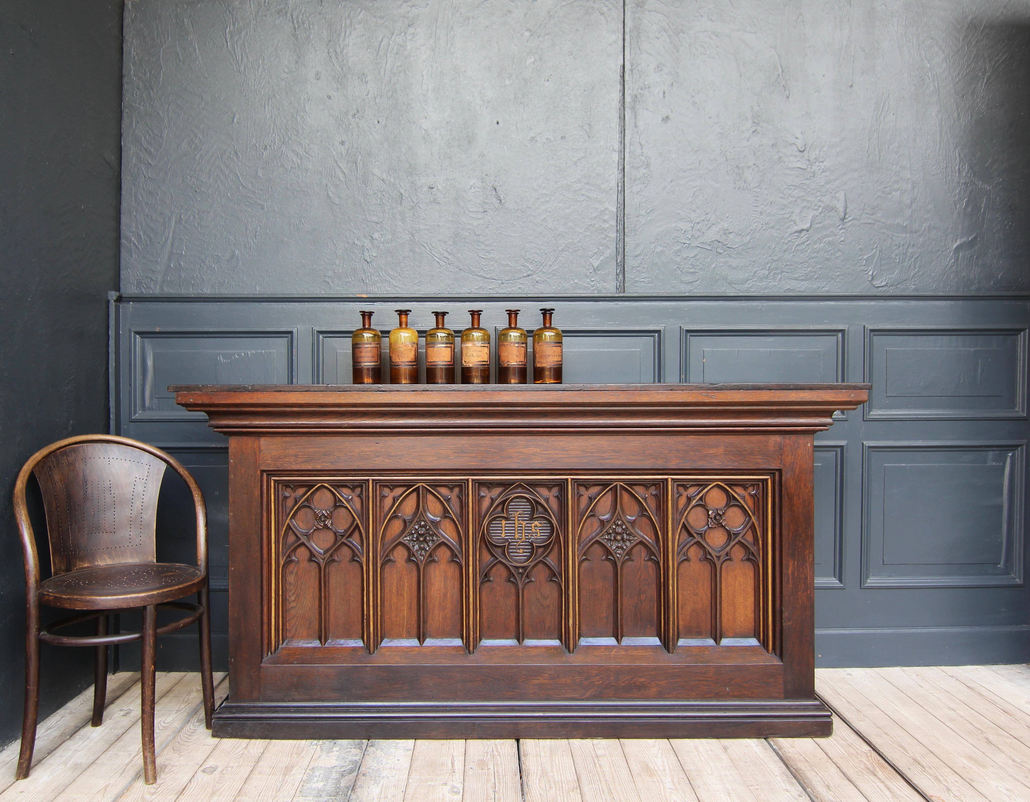 A gotchic revival counter from the late 19th century. Originally an altar table, this sacred piece of furniture was converted into a bistro counter in the 20th century. Made of solid oak with gold-coloured accents.

Oak body standing on a