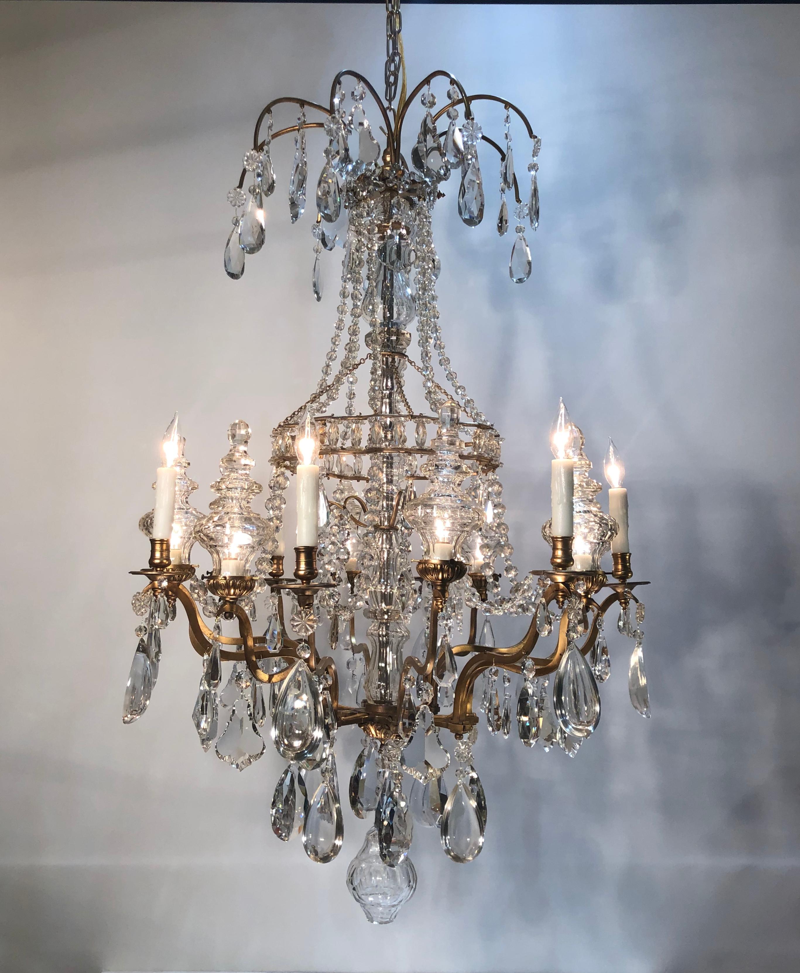 Magnificent 16-light French chandelier from the late 19th century. Very fine gilt bronze and crystal Louis XV style chandelier. Faceted cut crystal column surrounded with open gilded bronze birdcage frame. 16 branches, all adorned with faceted cut