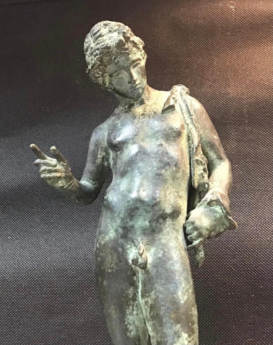 Grand Tour Bronze of Narcissus from Italy. A beautiful cast withwonderful verdigris patination overall. Very delicate details of hands, feet, and sandals. A copy of the original bronze discovered in Pompeii. Paper label on bottom. 10 1/2 inches tall.