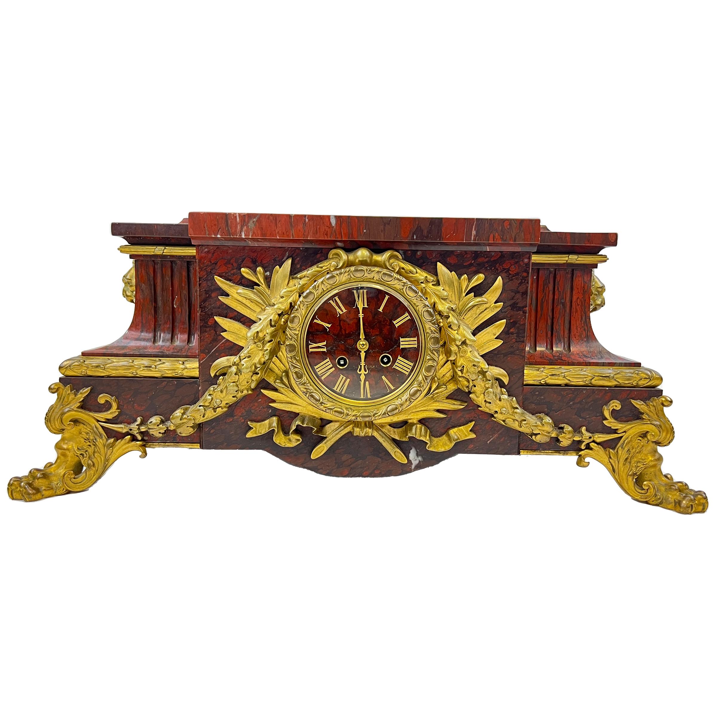 A fine example of Parisian Belle Époque craftsmanship, this monumental mantel clock made of Griotte marble and gilt-bronze, The red round dial is made of marble with roman numerals and signed 