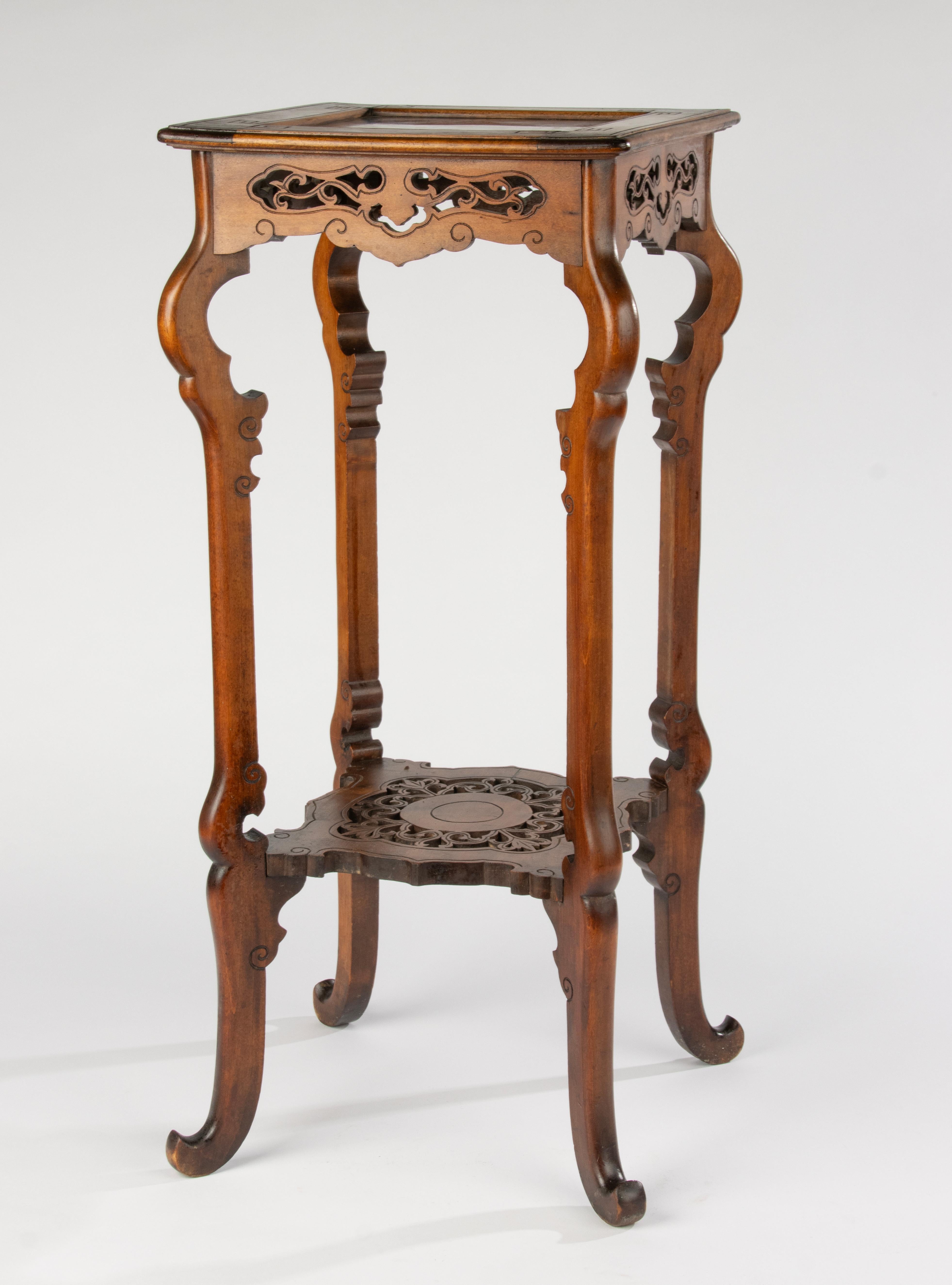 Elegante jardinera antigua con madera finamente tallada y una inserción de mármol rojo en la parte superior. La pieza es a la vez robusta y estable, y muestra una artesanía clásica con detalles decorativos calados y patas graciosamente curvadas. Se