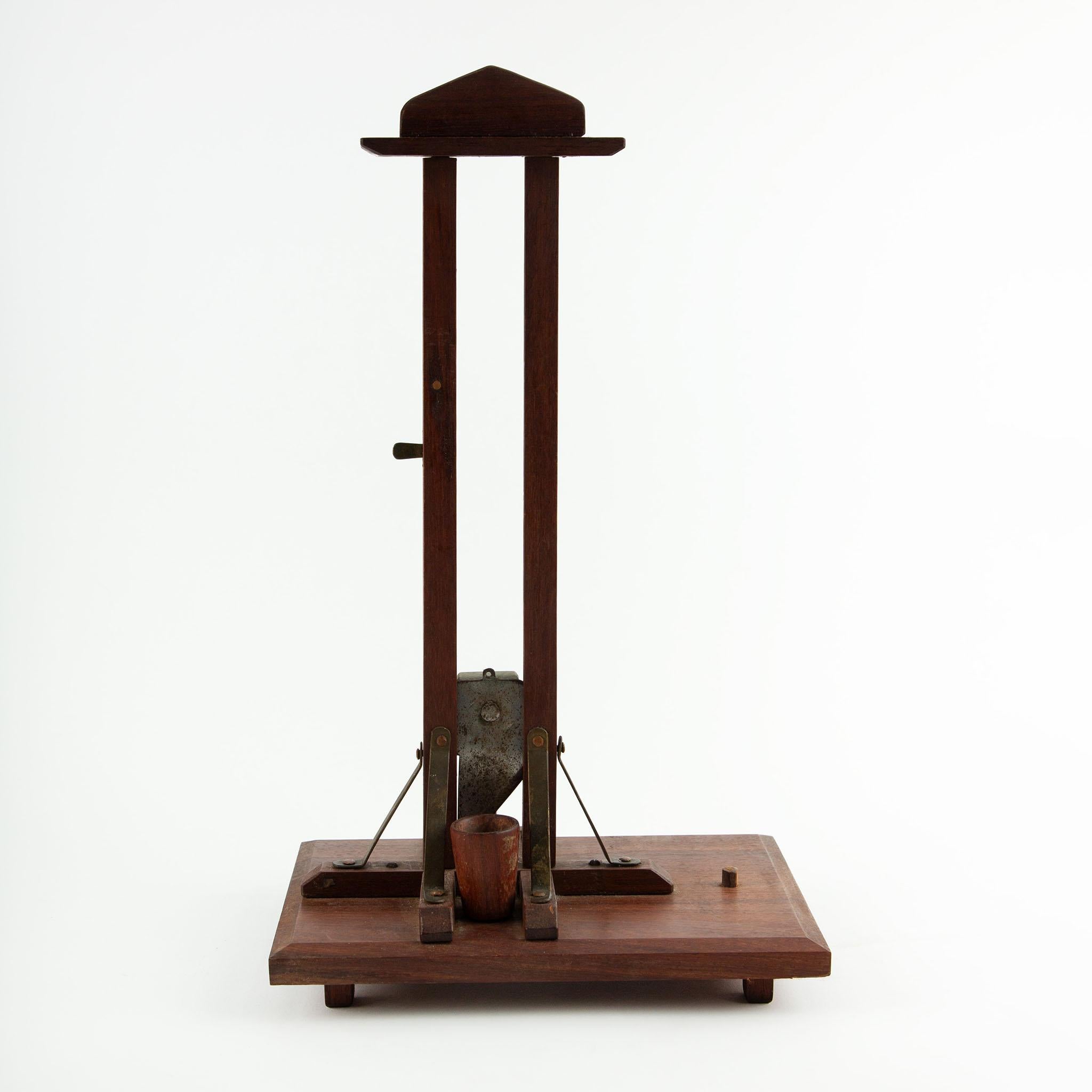 Late 19th-century French guillotine-style cigar cutter crafted in mahogany with brass and steel fittings. This functional tabletop cutter features a vertical blade mechanism weighted with a brass block, designed to deliver a precise, clean cut to