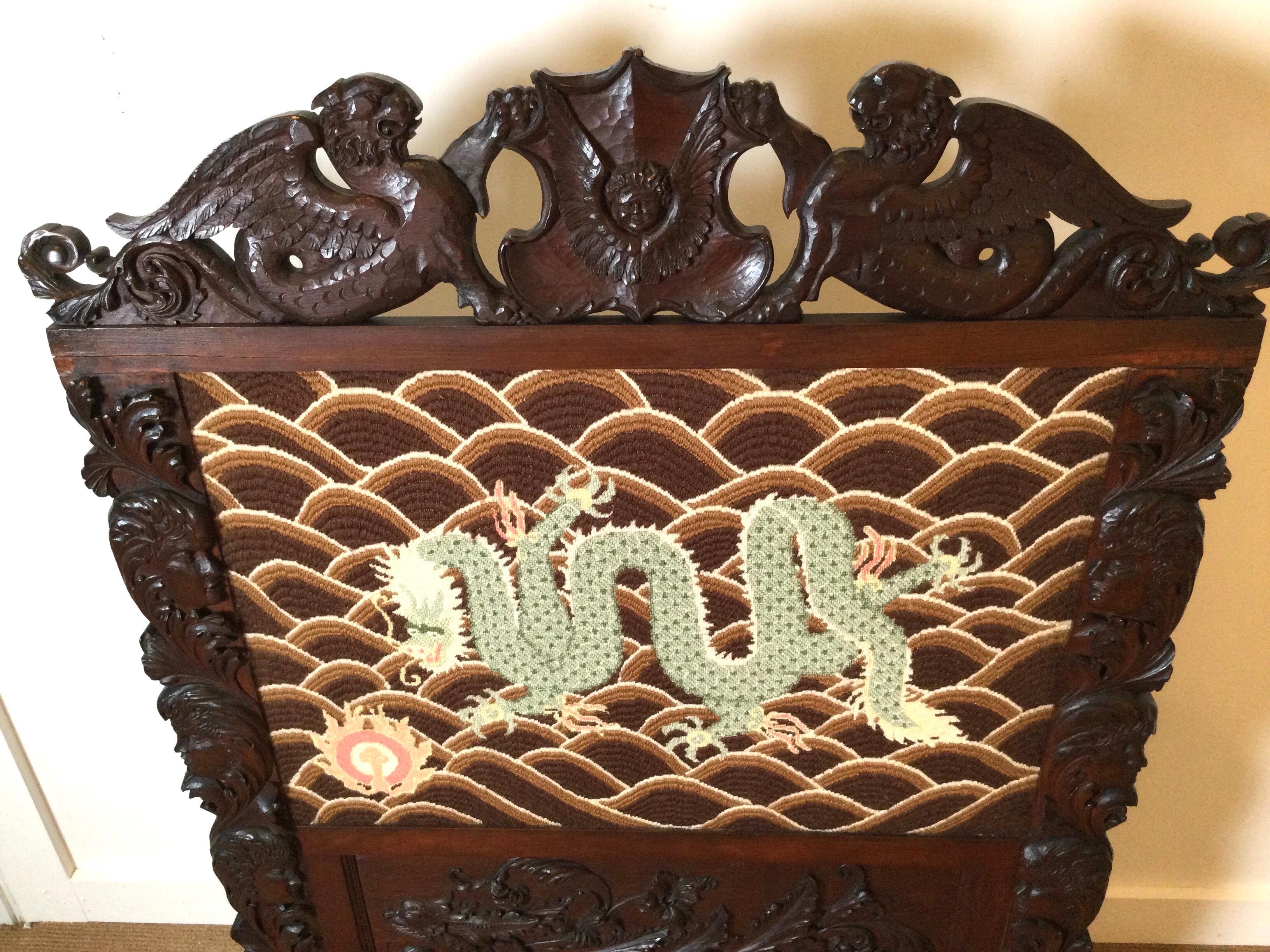 Late 19th century hand carved fire screen with needlepoint dragon motif.
Nicely carved giffins adorn the top and both sides have carved angelic faces.
All four carved paw foot support the screen.
Dimensions: 35.50