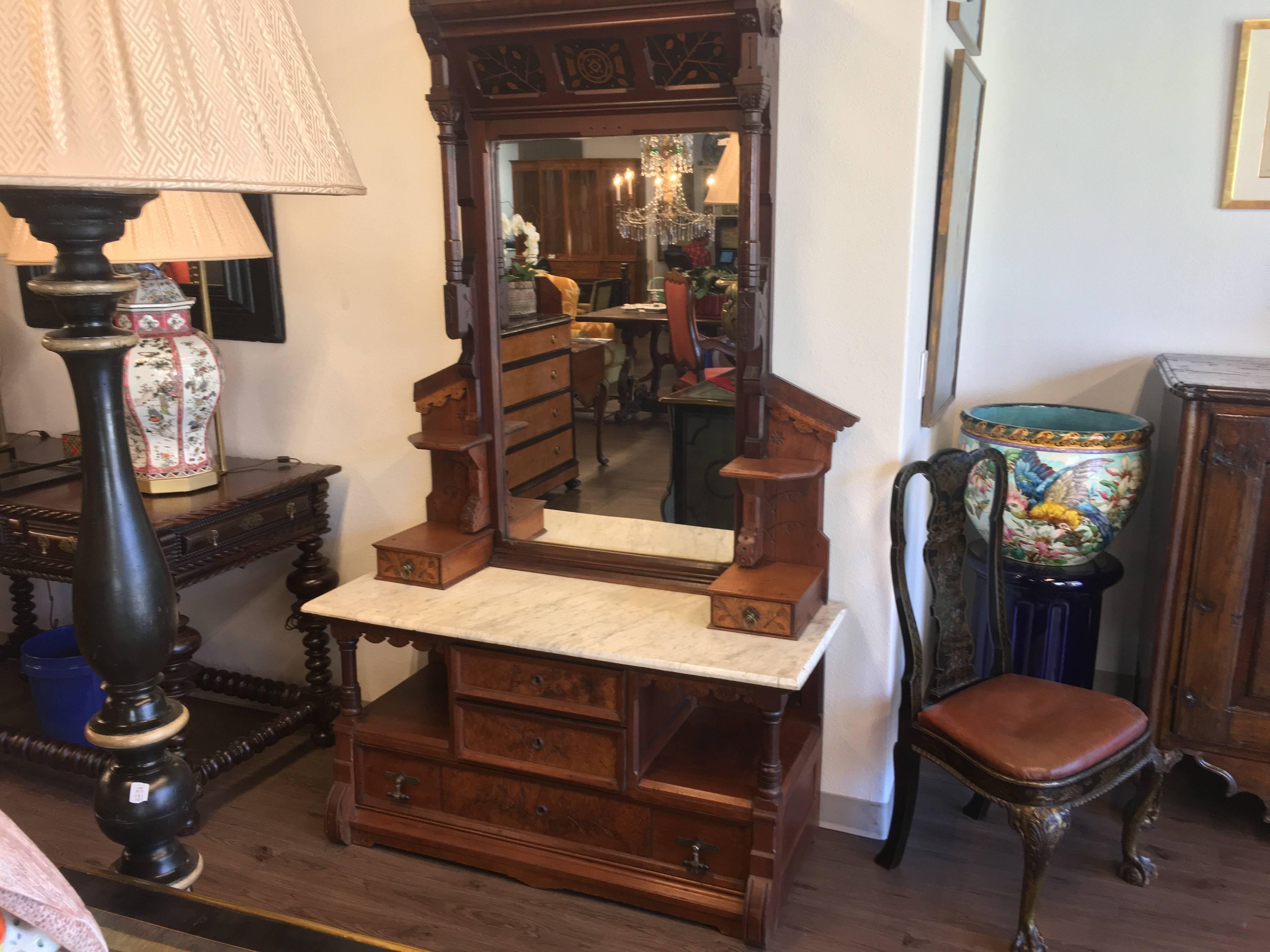 Late 19th century hand-carved walnut and rosewood Victorian Aesthetic Movement gentleman's dressing mirror with bianco venatino marble top. This piece stylishly epitomizes the transitional mid-19th century Eastlake sensibility to the more simpler,