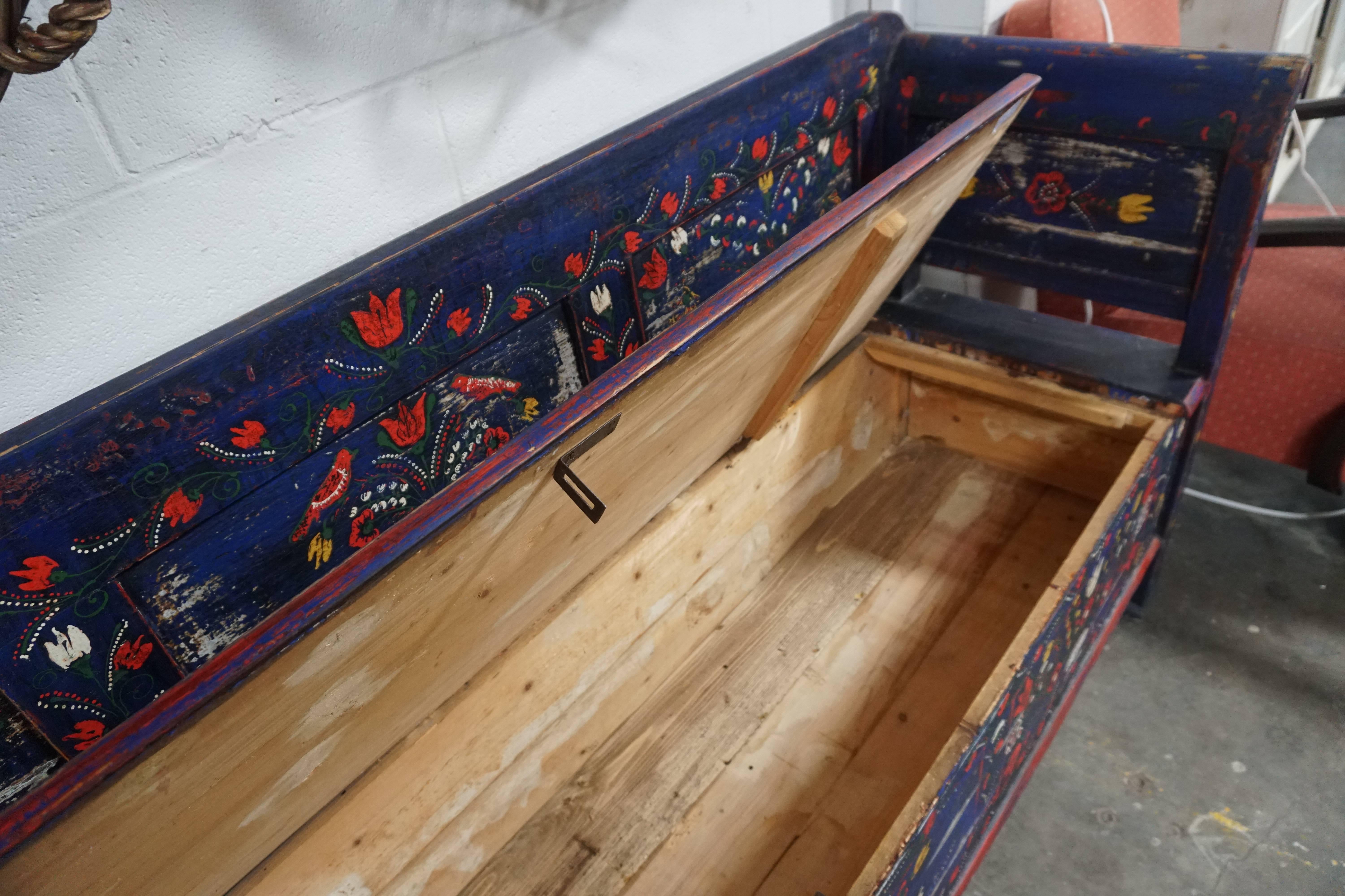 Beautiful hand-painted pine bench from late 19th century Scandinavia. Seat is hinged, providing ample hidden storage beneath. Designs feature hand-painted tulips and wildflowers.