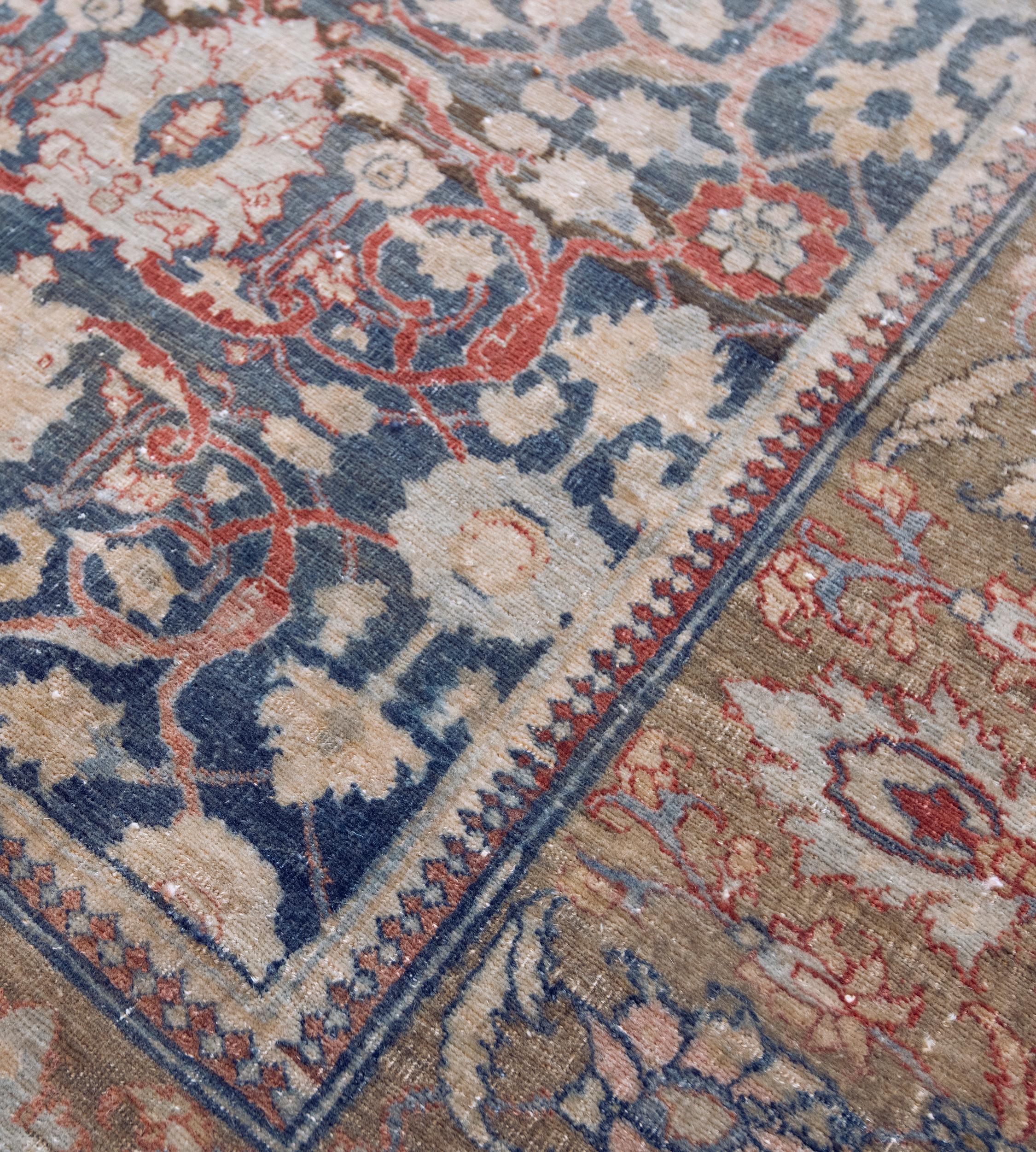 Questo runner tradizionale di Tabriz presenta un campo indaco sfumato con un disegno generale di vite rosso pomodoro sfumato che collega audaci palmette blu chiaro e marrone buffo e delicate strisce di vite floreale, in un ampio bordo verde kaki di