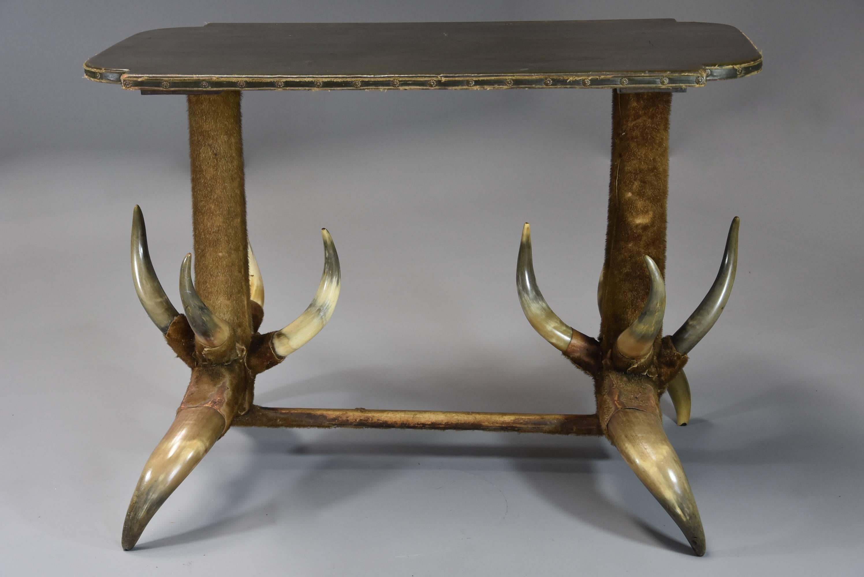 Late 19th century highly decorative and unusual German cow horn table in rare, original condition.

The table consists of a shaped pine top covered with its' original deep green faux leather, possibly Rexine, this being secured with brass