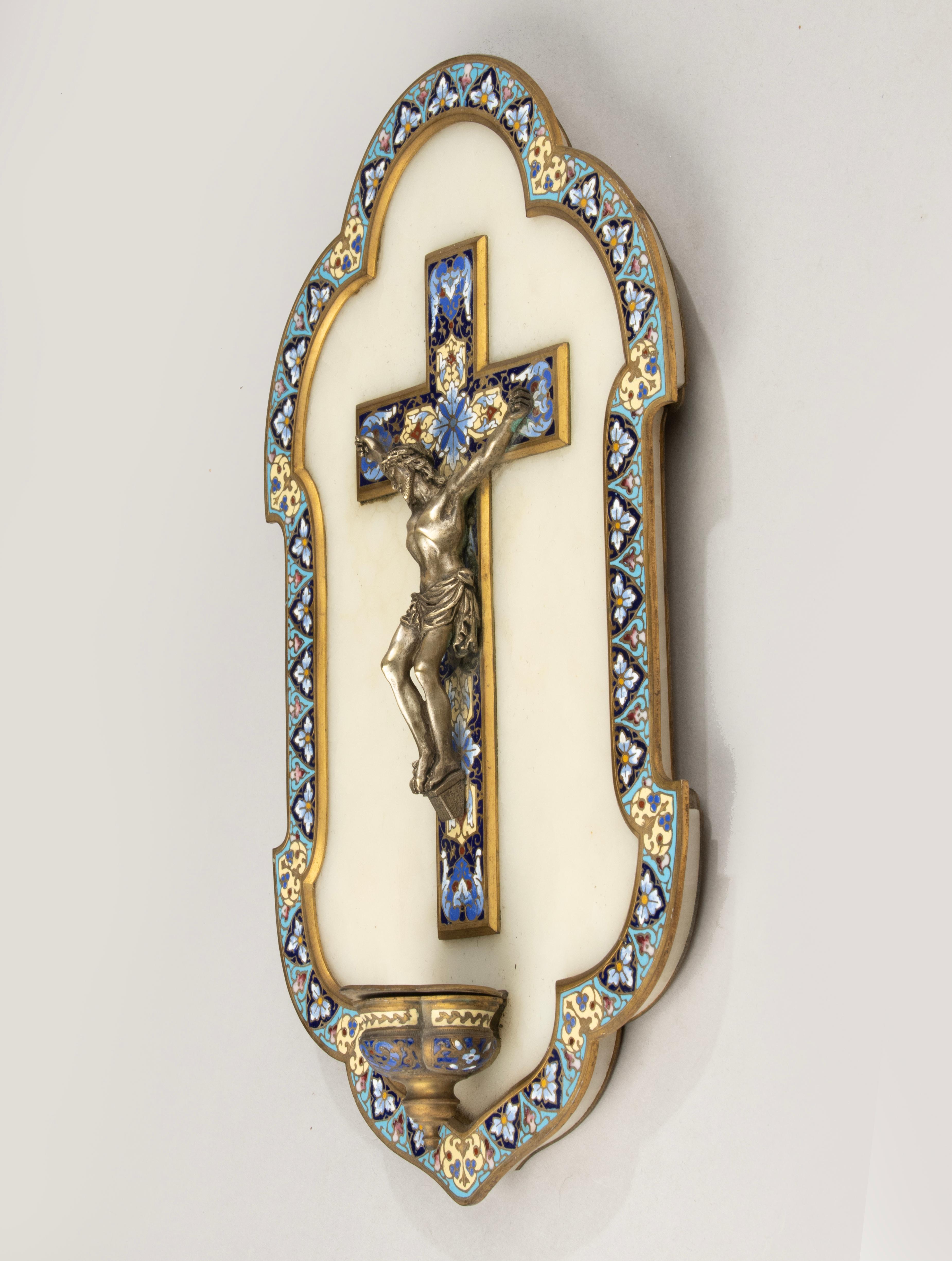 Un bénitier raffiné comporte un crucifix finement détaillé, représentant le Christ dans une posture traditionnelle de sacrifice et de sérénité. En son centre se trouve une figure du Christ crucifié en bronze finement coulé, montée sur une croix
