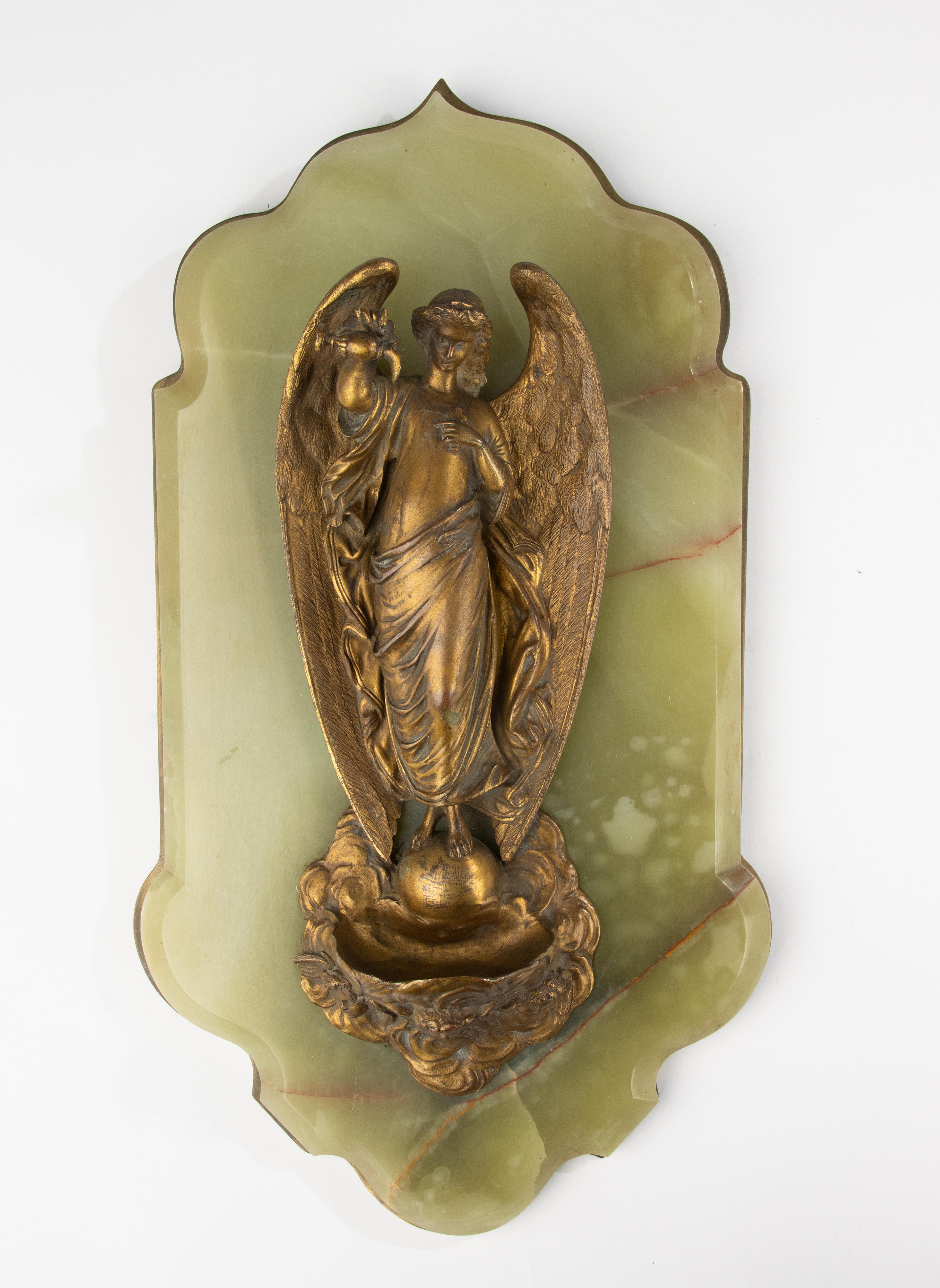 Elegant bénitier français datant d'environ 1890-1900.
La pièce présente une figure en bronze finement détaillée d'un ange tenant un récipient, montée sur une plaque arrière en onyx vert magnifiquement façonnée avec un support en cuivre. La qualité