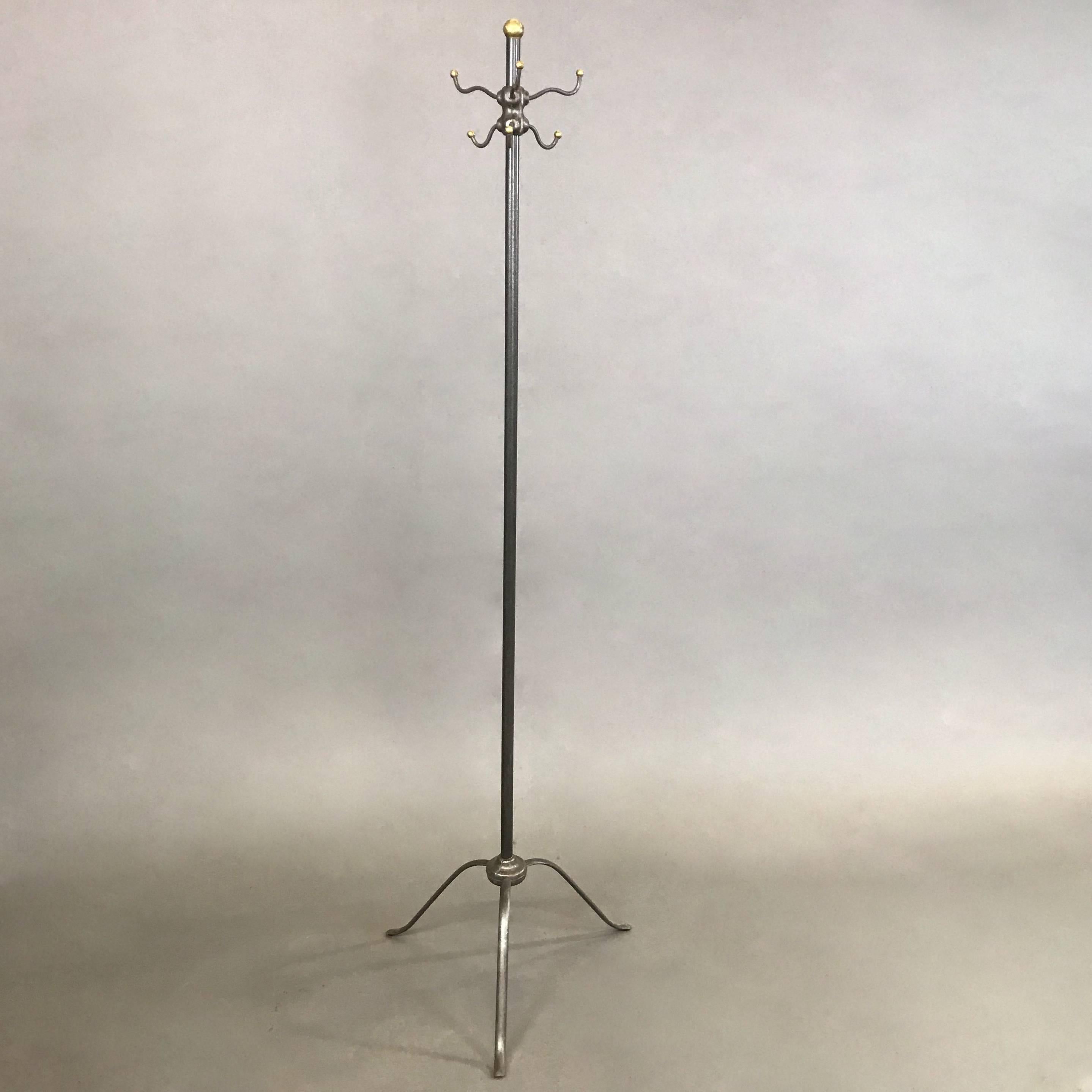 Elegant, antique, late 19th century, industrial, brushed steel coat rack features brass ball details with a slender three prong base.