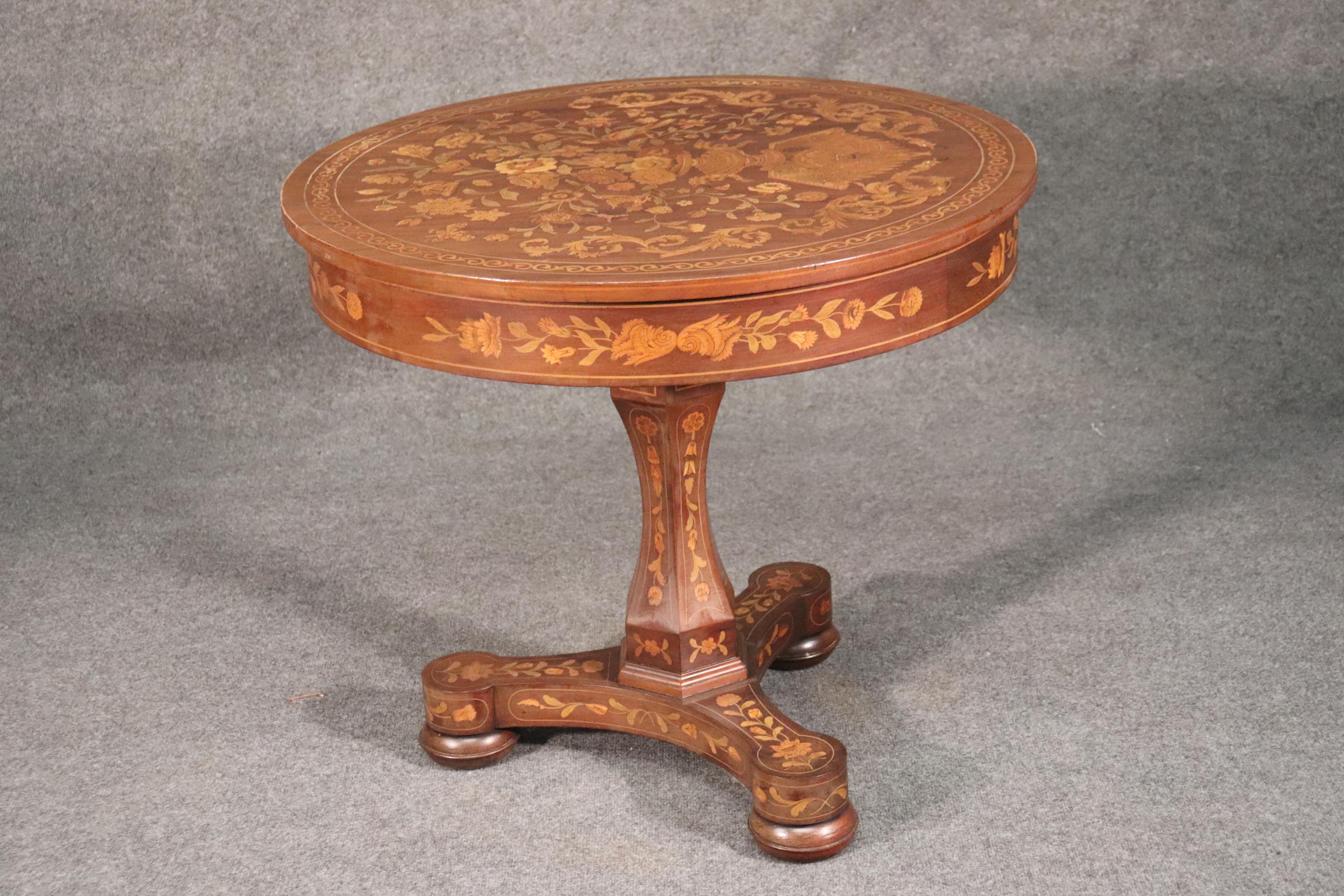 This is a beautiful inlaid Dutch marquetry center table of reasonable size. The table features stained tulip wood and satinwood inlay and a mahogany frame. The table measures 33 wide x 33 deep x 29 tall. The table is in good antique condition.