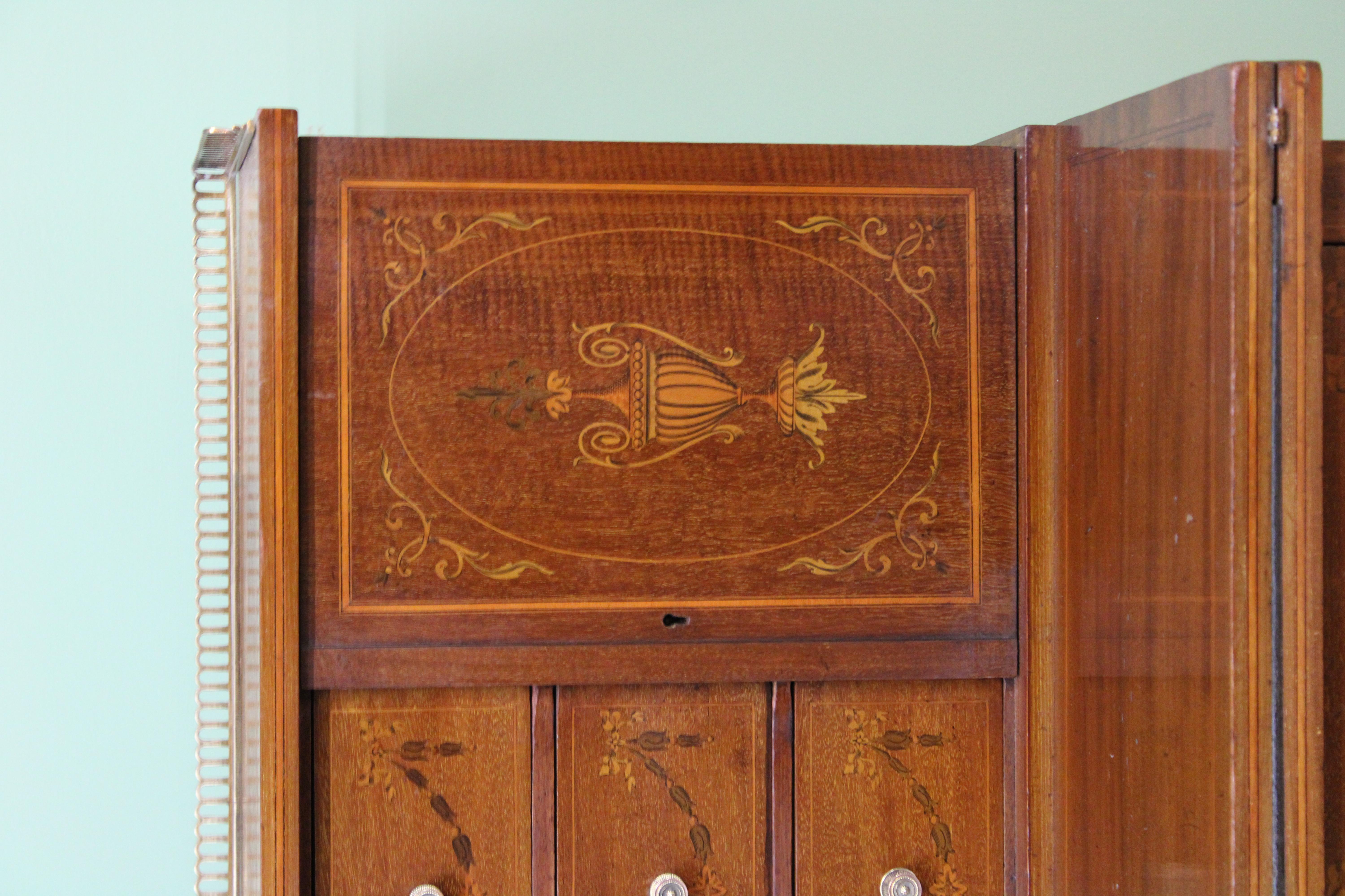 A fine quality late 19th century inlaid mahogany Bonheur du jour. Of excellent construction by the prestigious cabinet makers Jas Shoolbred & Co. Decorated with inlaid detailing of swags, urns, garlands and harebells throughout. The super-structure