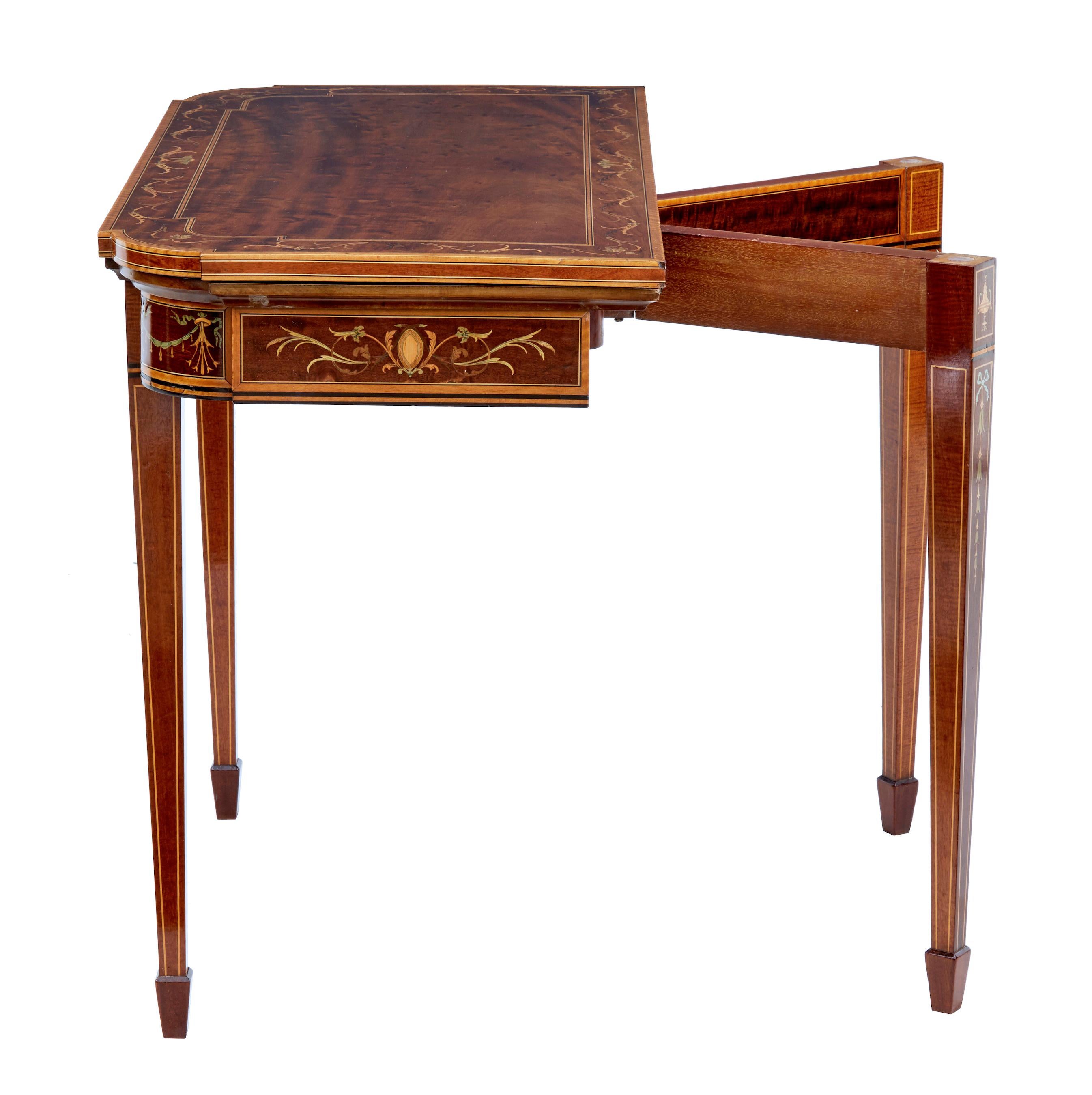 Late 19th century inlaid mahogany card table by Edwards and Roberts. Fine quality card table made by renowned English makers Edwards and Roberts. Beautiful plum pudding mahogany top inlaid with satinwood, boxwood, ebony and walnut. Back legs swing