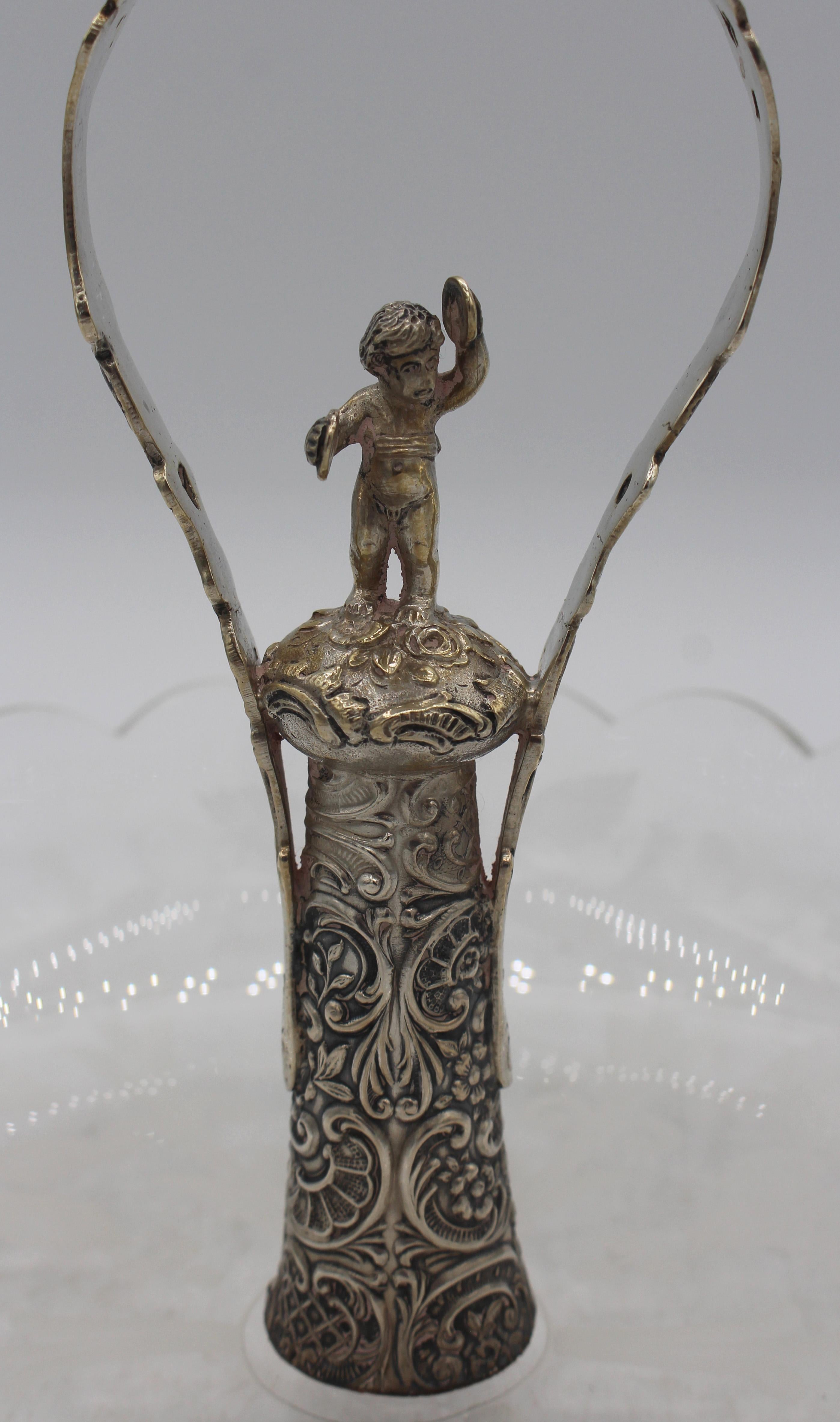 Piatto per caramelle in vetro e argento della fine del XIX secolo, probabilmente italiano. Piatto in vetro soffiato con intagli e manico in argento Continental 800 standard centrato da un putti che suona i cimbali.

Diametro 7,5