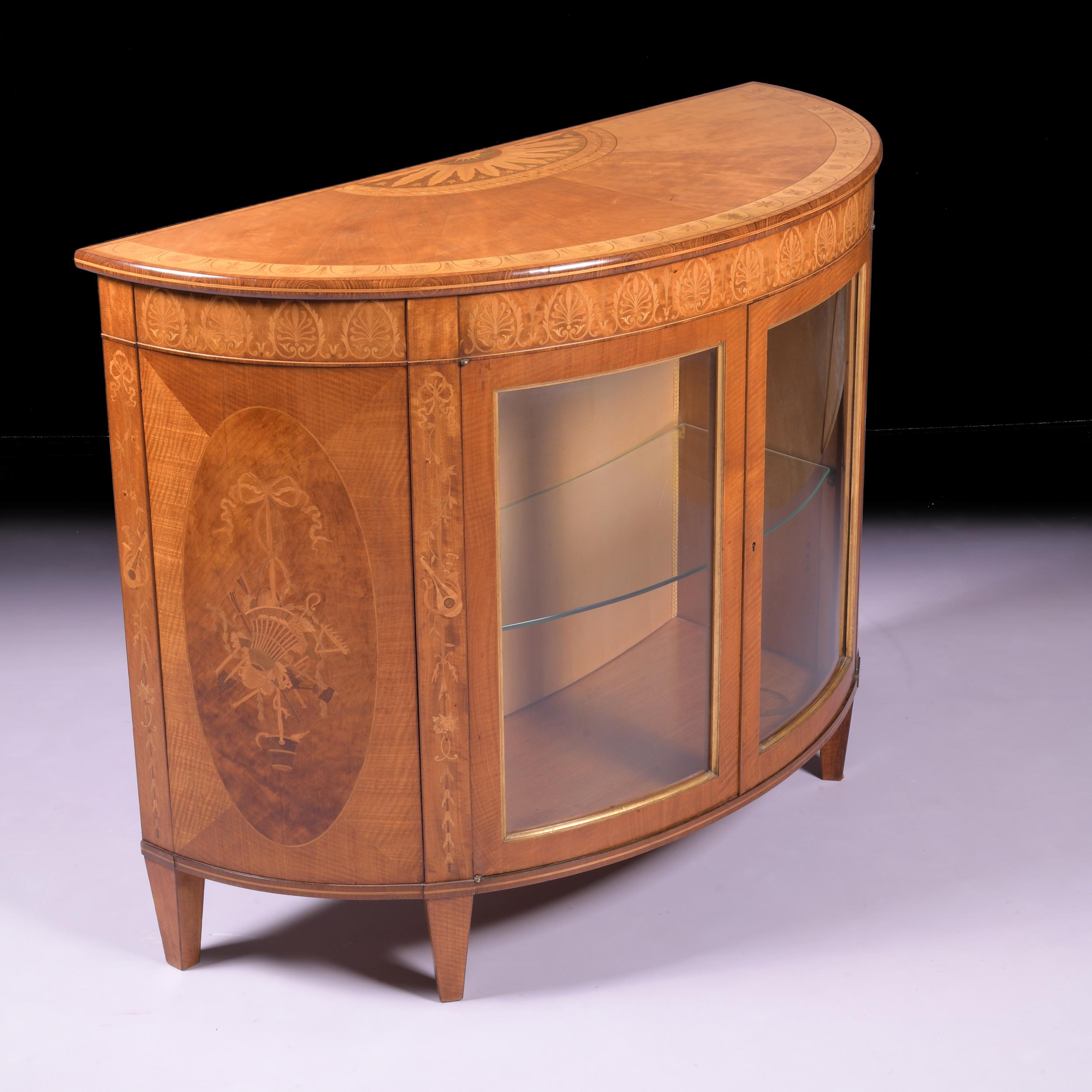 A magnificent satinwood and marquetry inlaid semi elliptical commode by James Hicks of Dublin. The rosewood banded top inlaid with a half patera with floral bandings with an outer band of stylised flower heads, and a band of flowerheads, and