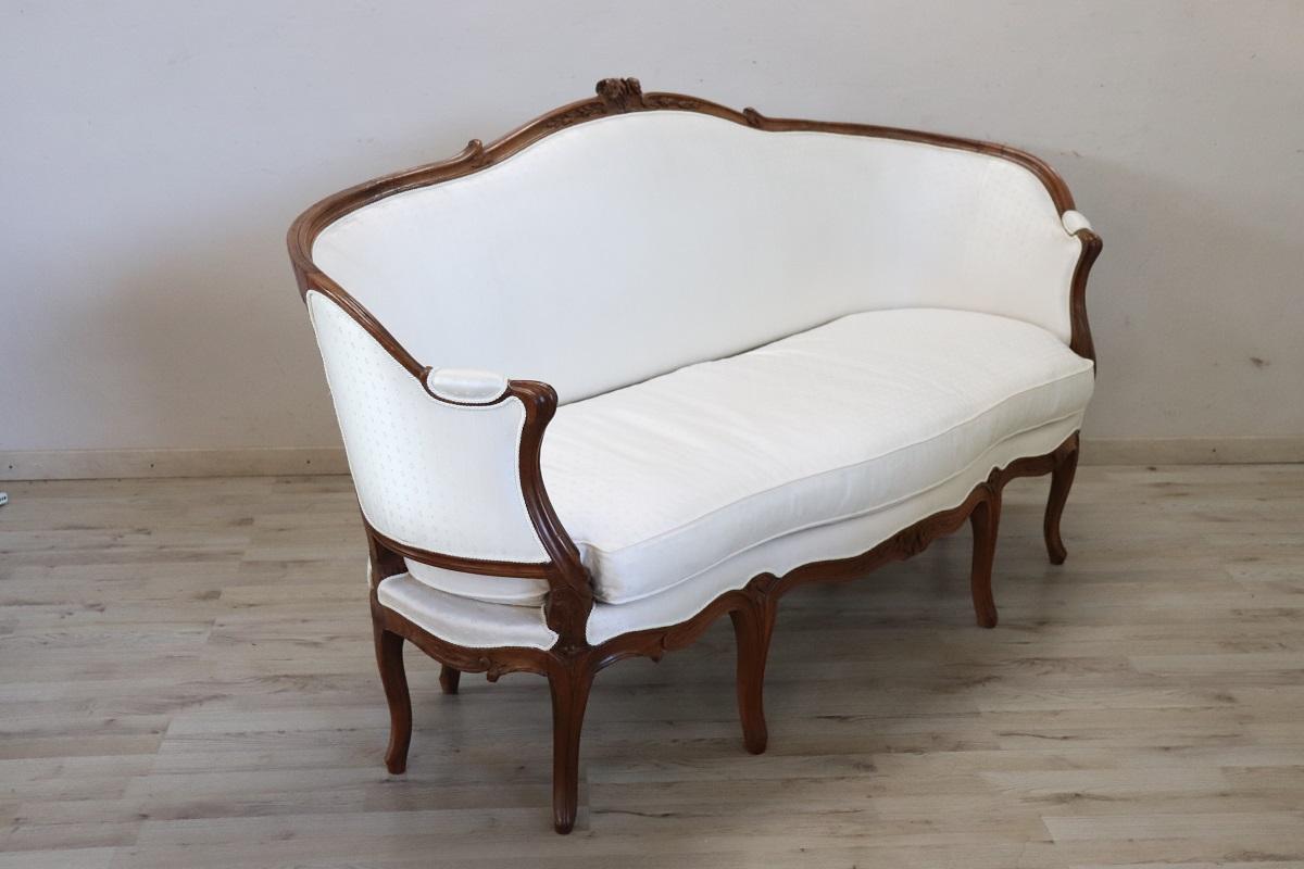 Te ofrecemos este antiguo sofá italiano de finales del siglo XIX.

El sofá tiene una sólida estructura de nogal y un cómodo asiento y respaldo tapizados. Su diseño se inspira en las líneas fluidas del Barroco, alternadas con refinadas y sutiles
