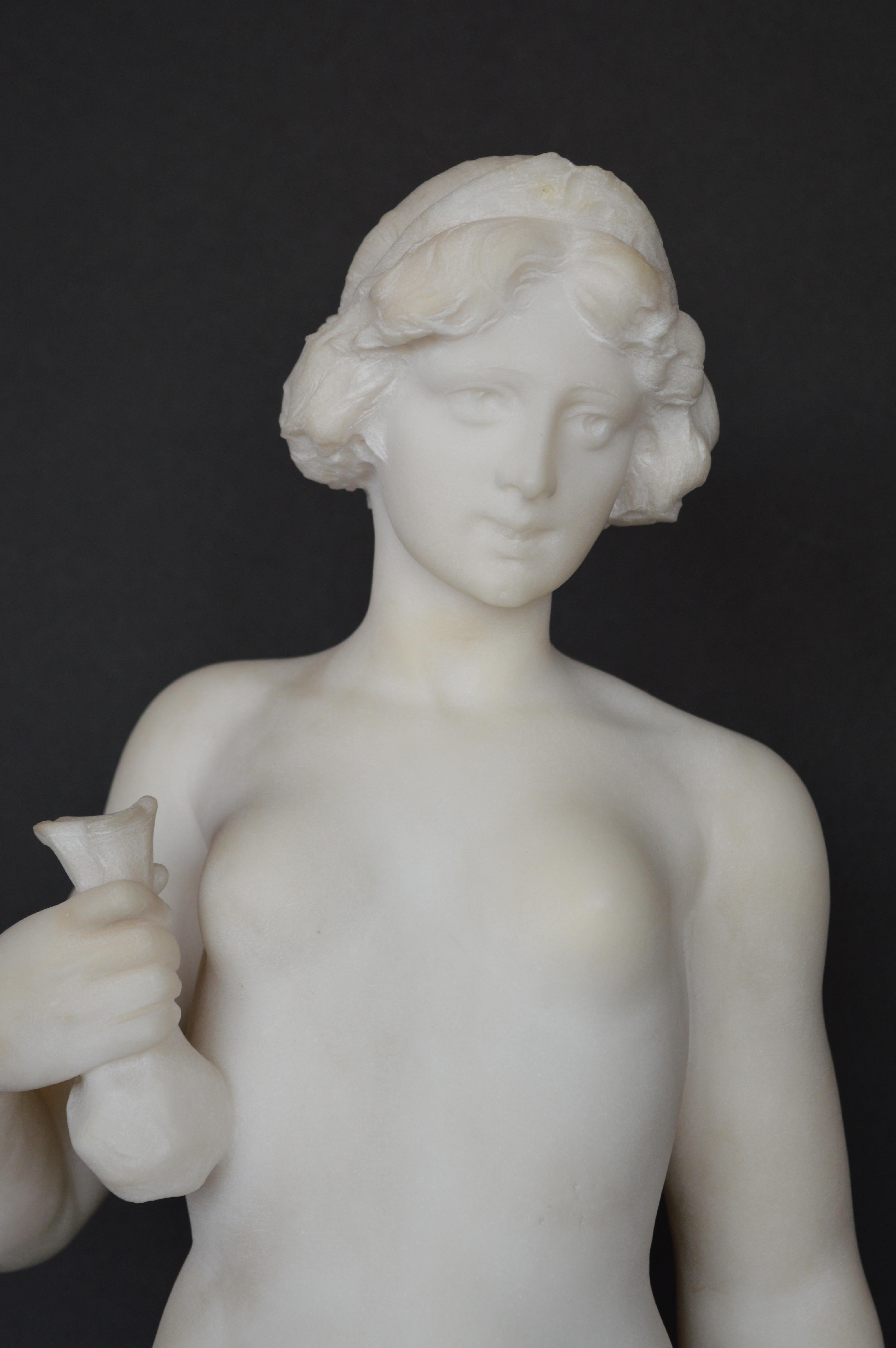 Statue en marbre de Carrare d'une jeune fille semi-nue. Tenant des roses dans une main et un vase dans l'autre. Timbré à la base G67573.