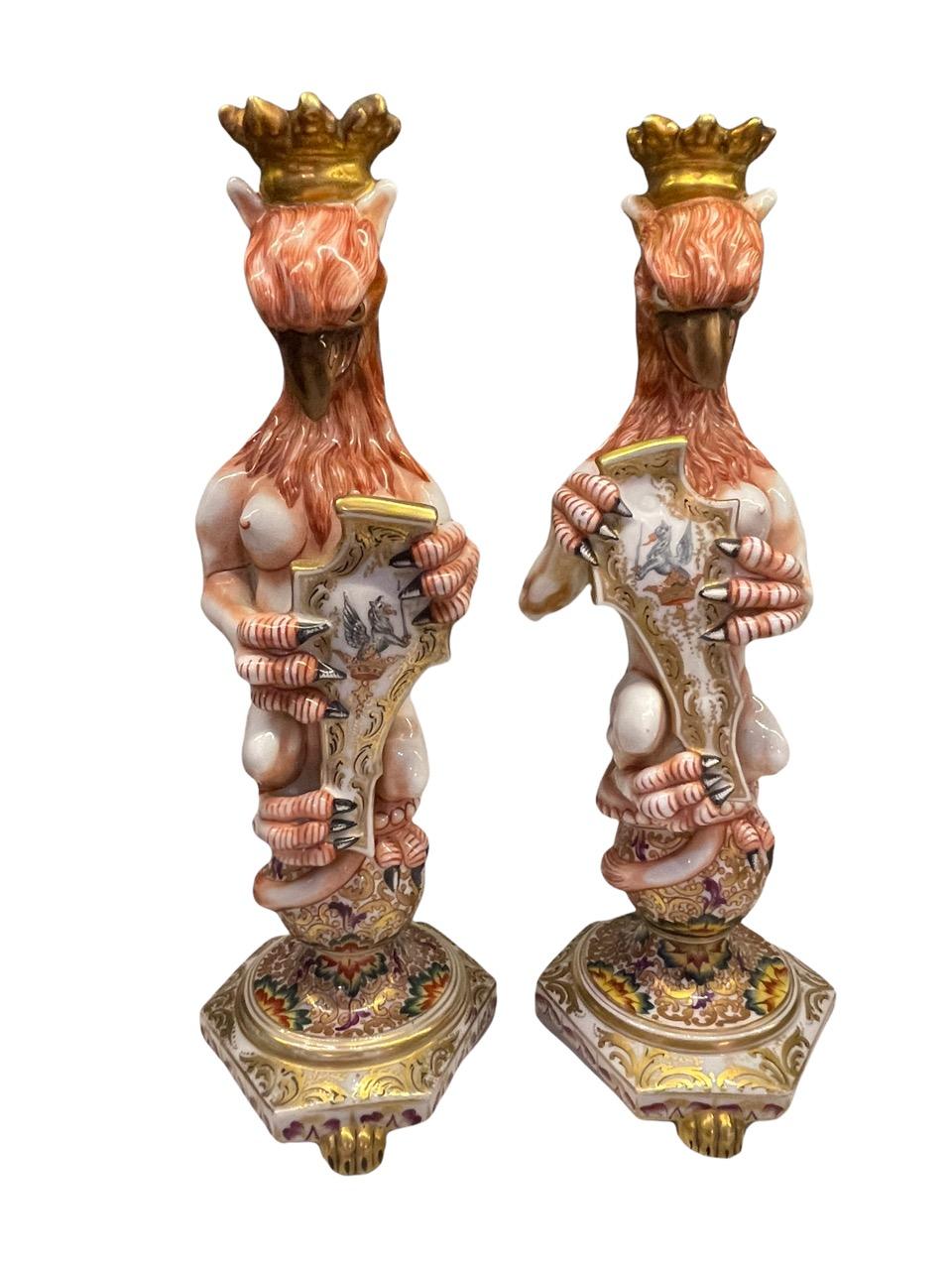 Capodimonte 19th Century Italian opposing pair of majolica crowned and winged griffon figures. Both are signed on the bottom base with the signature used from 1771 - 1834. Each featured grasping a shield with painted griffin motifs, and meticulously