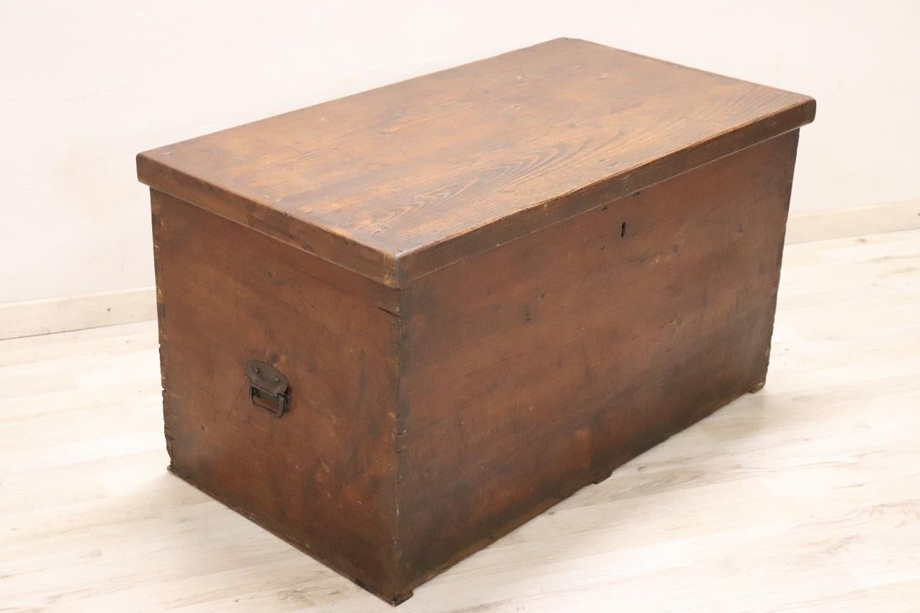 We are delighted to present this rustic antique Italian trunk, dating back to the end of the 19th century. Crafted from solid fir wood, this trunk exudes a charming rustic appeal, characterized by its intense brown color that imparts a warm and