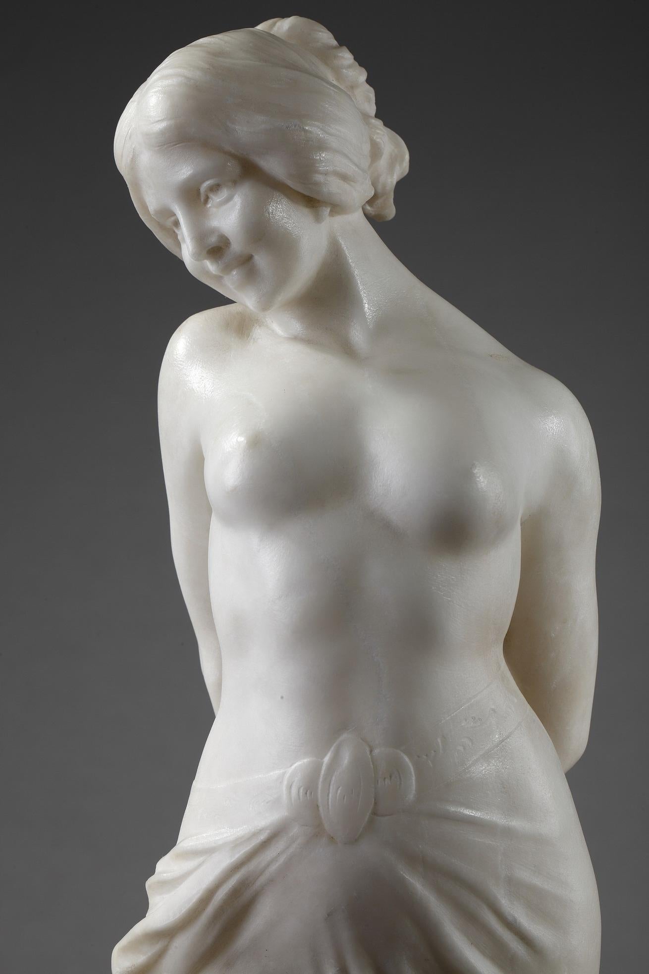 Art Nouveau Italian statue beautifully carved of alabaster. The charming nude woman is smiling. Her pose, with her hands gathered behind his back, accentuates her full feminine sensual curves. She rests on a small base and plinth. This alabaster